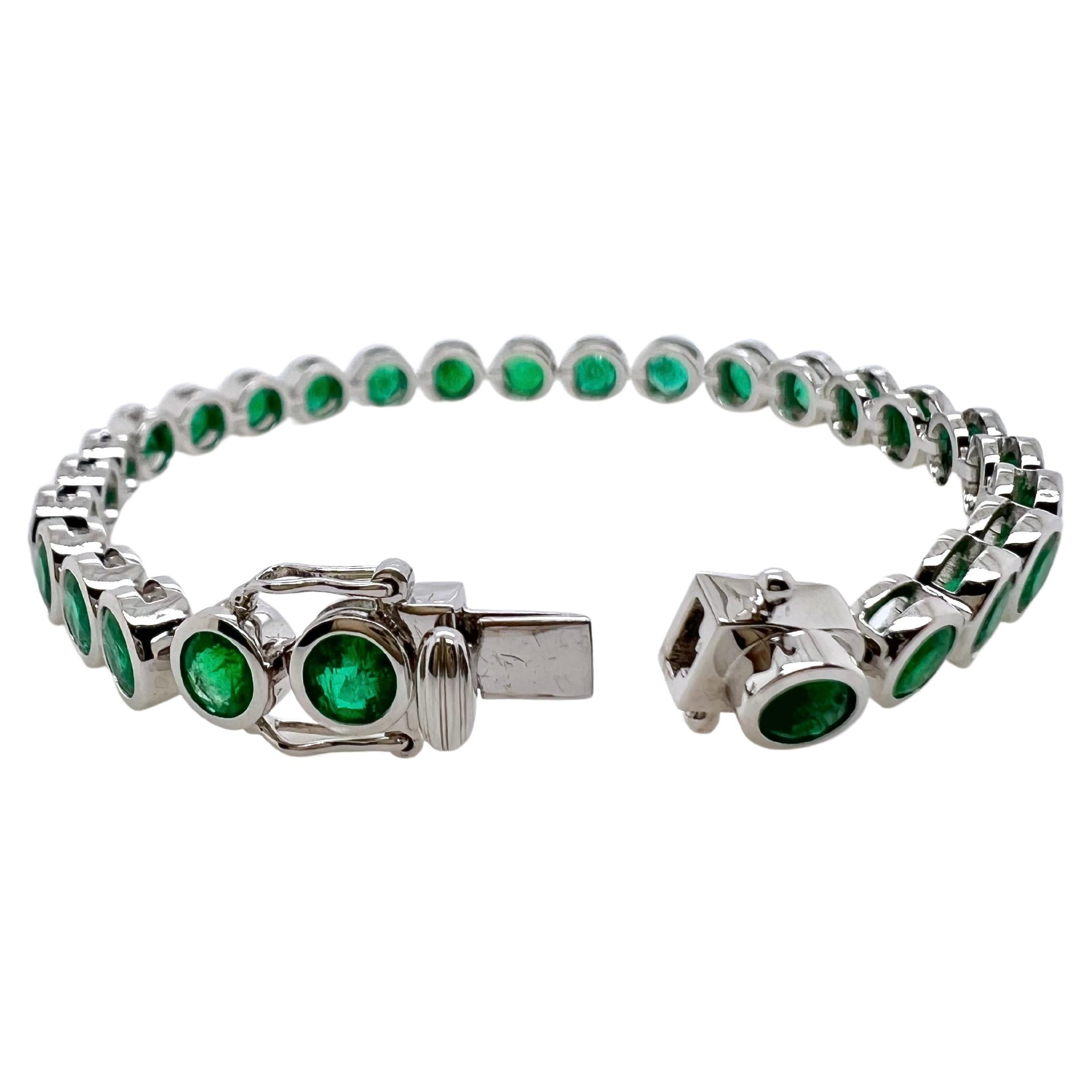 This is not an ordinary bracelet.  The round cut emeralds are bezel set in an 18k white gold mounting that fully exhibits
and emphasizes the emeralds.  Just a straight line of emeralds that can be worn and stacked amongst your other
bracelets or it
