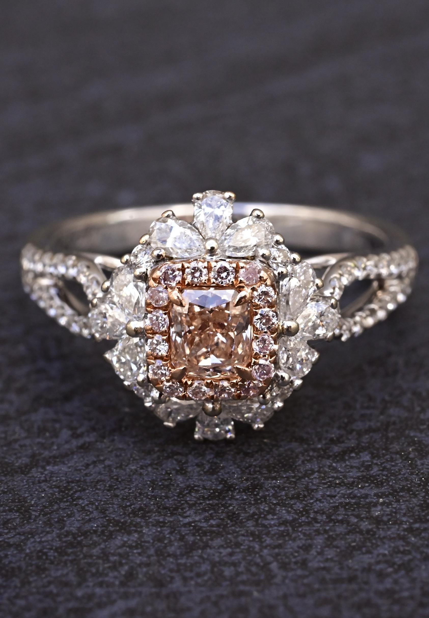 Stunning 18K White Gold Fancy Pink Diamond Halo Ring – IGI Certified
This exquisite designer ring is crafted in luxurious 18K white gold and features a captivating center diamond graded as a natural fancy pink-brown, cut-cornered rectangular