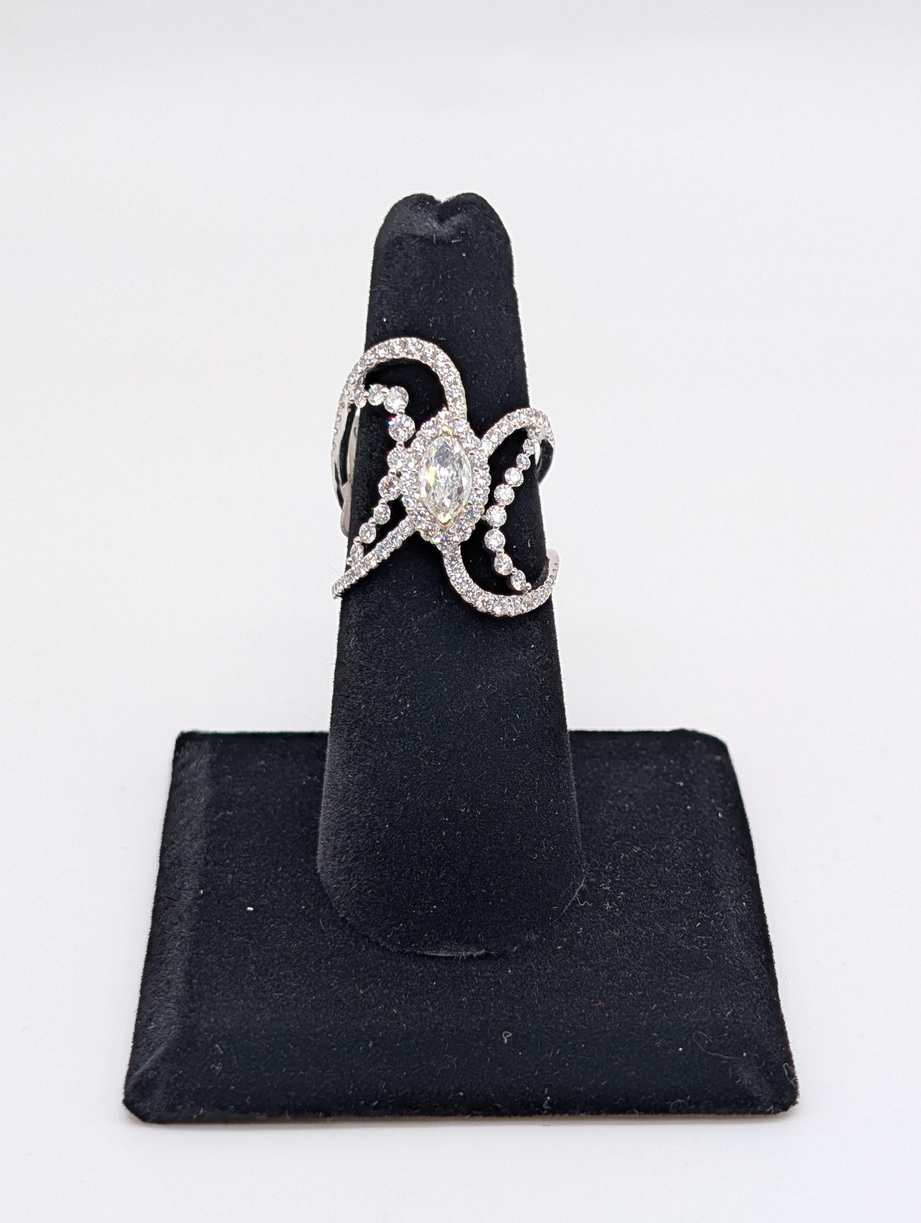 Questo elegante anello in oro bianco da 18 carati presenta una splendida combinazione di 1,22 carati di diamanti rotondi, splendidamente disposti per ottenere il massimo dello splendore e della brillantezza. Al centro, l'anello è impreziosito da un