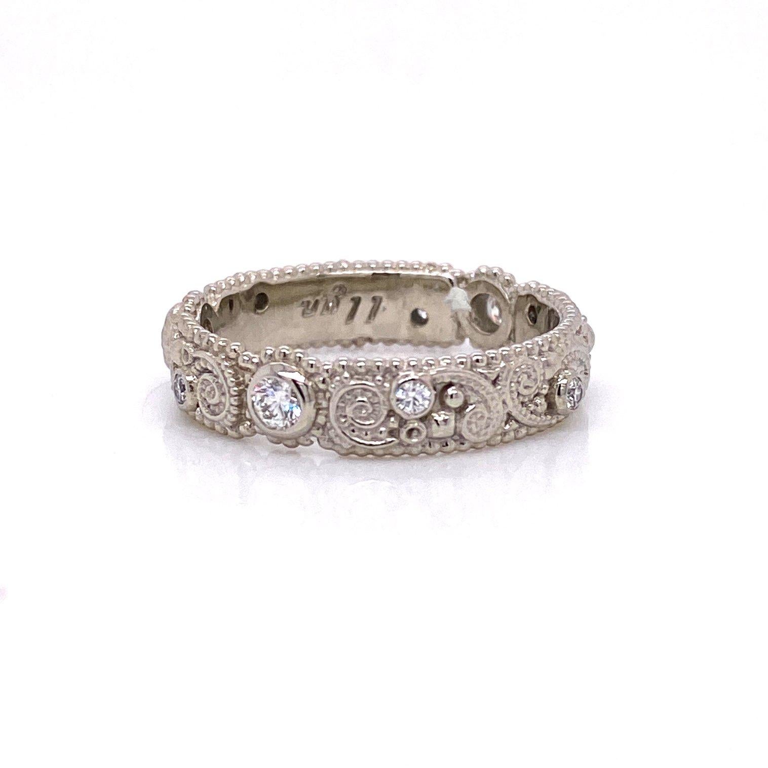 An 18k white gold llyn Band bezel set with round full cut white diamonds 0.25 total carat weight VS clarity F color. Designed and made by llyn strong. Ring size 7