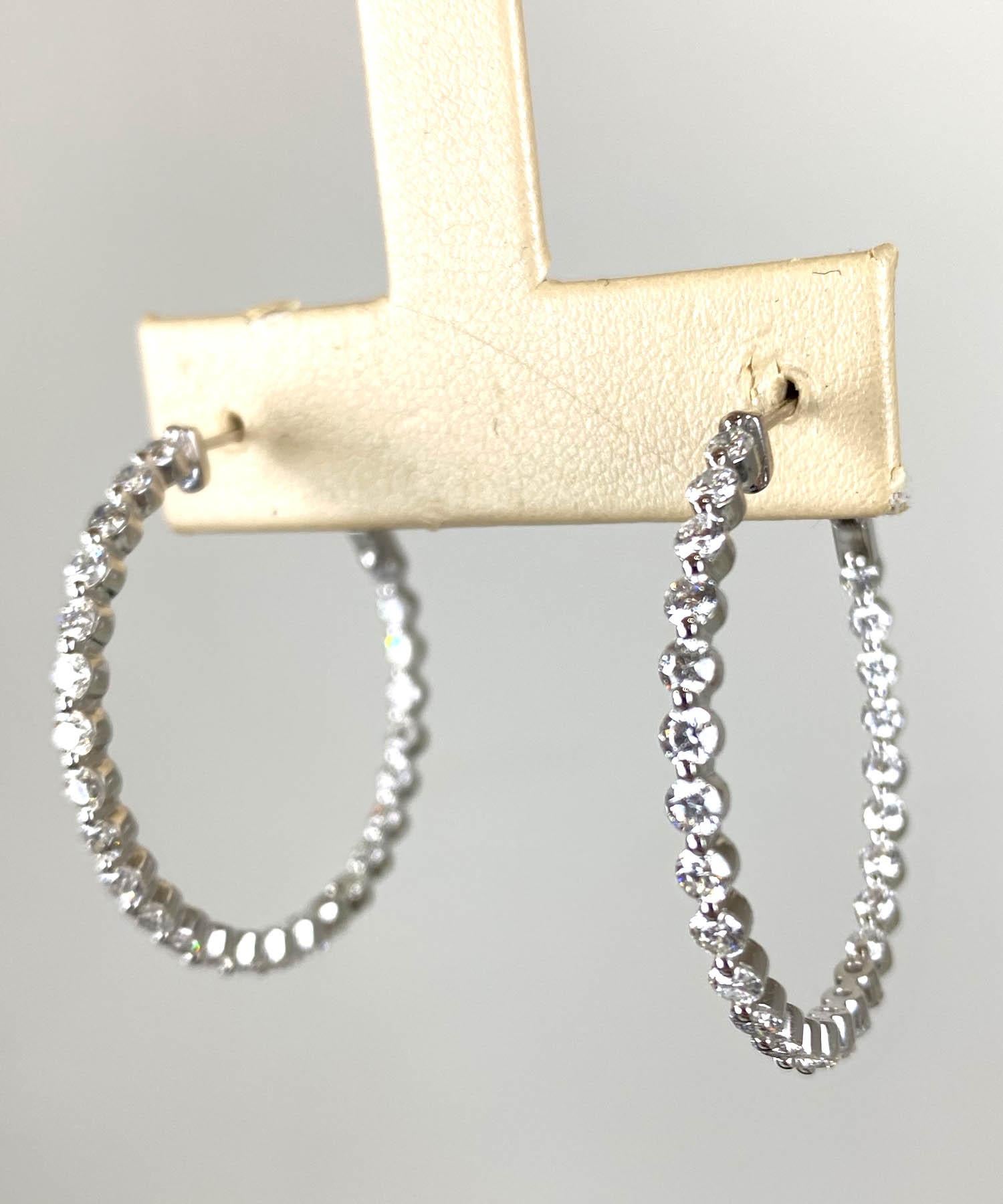 Beautiful hoop earrings are composed of 18k white gold with floating diamonds at the front and inside forward facing back of the hoop with English lock closures at the back. 

Diamond information:
Diamonds are inspected by a certified GIA
Weight:
