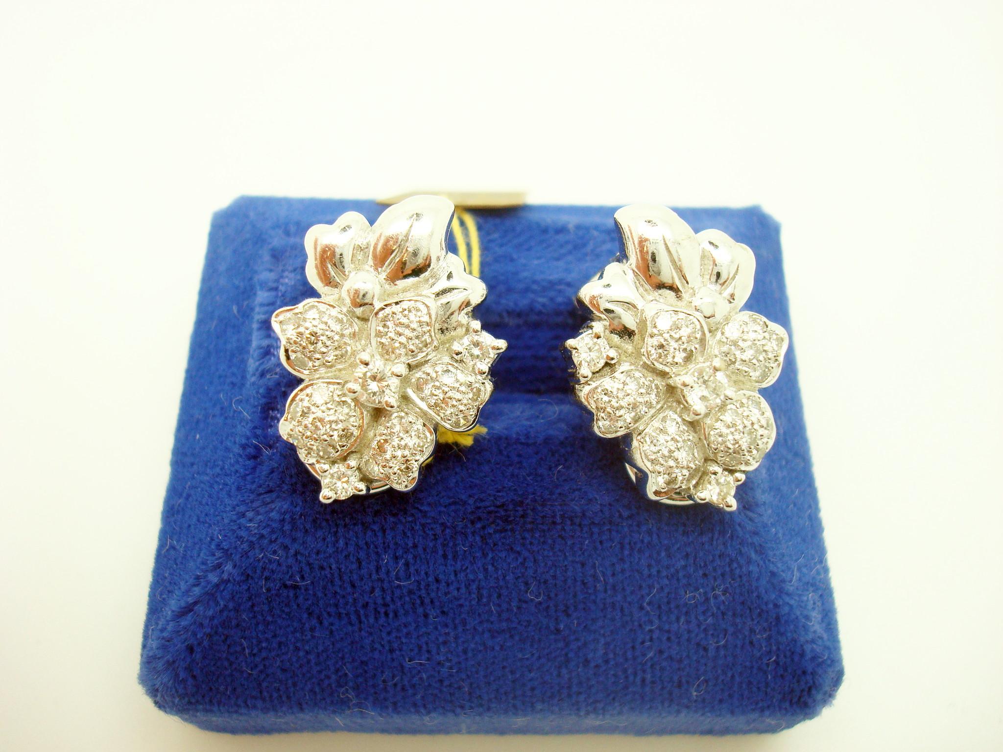 18k White Gold Genuine Natural Diamond Flower Earrings 1.2 Carats (#J1779)

18k white gold diamond earrings in the form of a flower featuring 1.2 carats of round brilliant cut diamonds. The three larger diamonds are prong set, and the surrounding