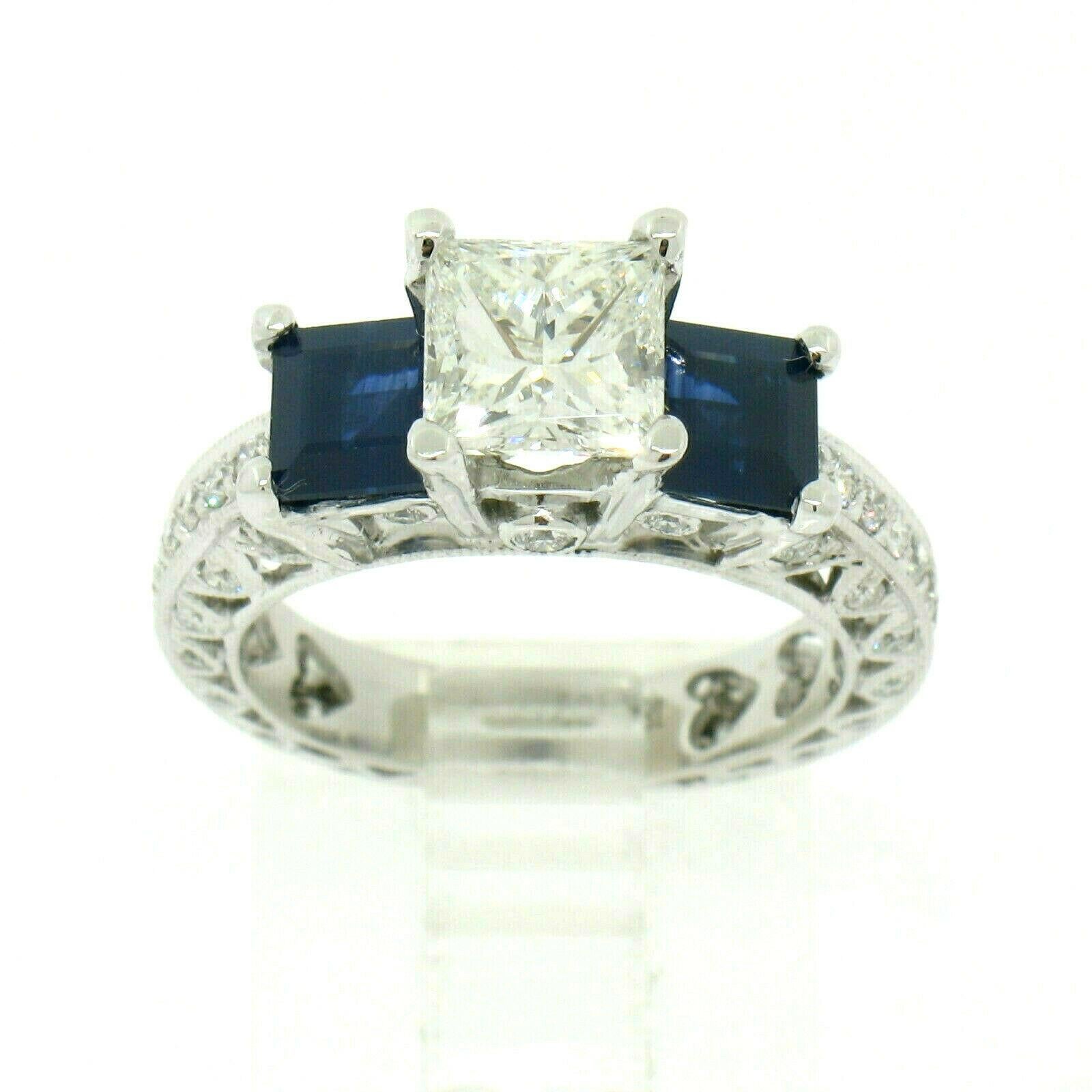 You are looking at a stunning diamond and sapphire engagement ring crafted in solid 18k white gold. The ring features a spectacular princess cut diamond solitaire, prong set at the center of the design. This center diamond is GIA certified, weighs