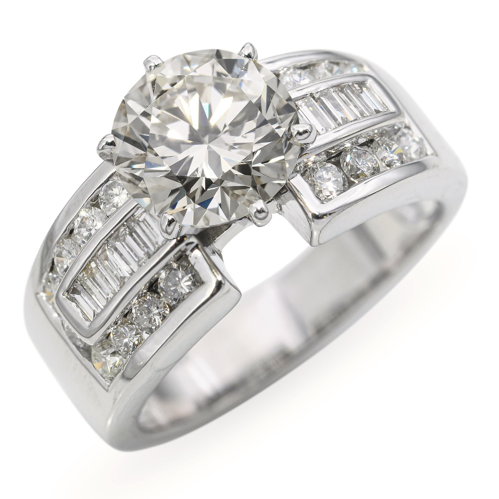 This vintage 18k white gold engagement ring features a GIA-certified 2.03ct center diamond with an SI1 clarity and faint brown hue, offering a warm and unique character. Accented by an additional 0.70tcw of brilliant-cut diamonds along the band, the