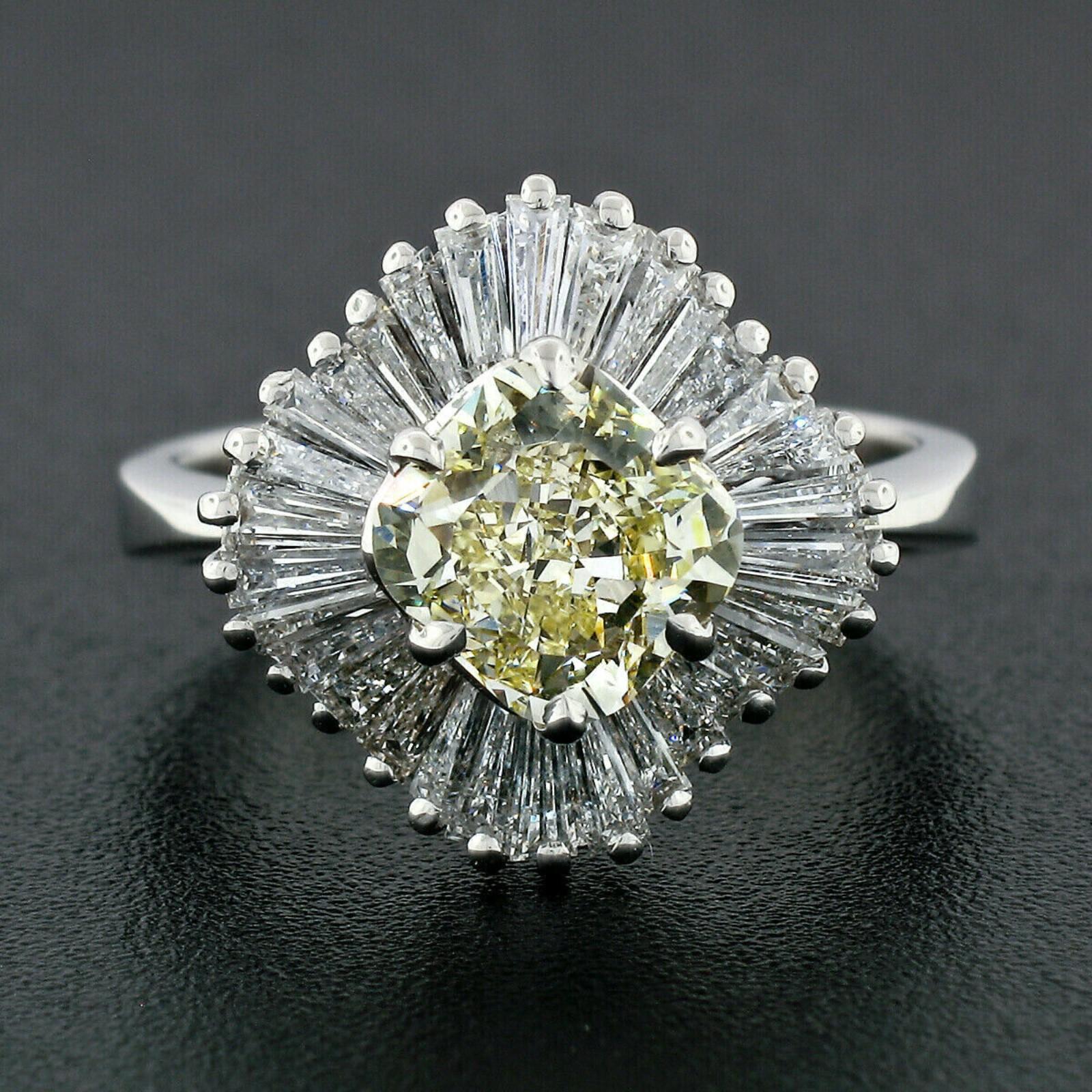 This truly jaw dropping engagement or cocktail diamond ring is crafted in solid 18k white gold and features a gorgeous, GIA certified fancy light yellow diamond solitaire prong set at the center of the design. The GIA diamond is certified as