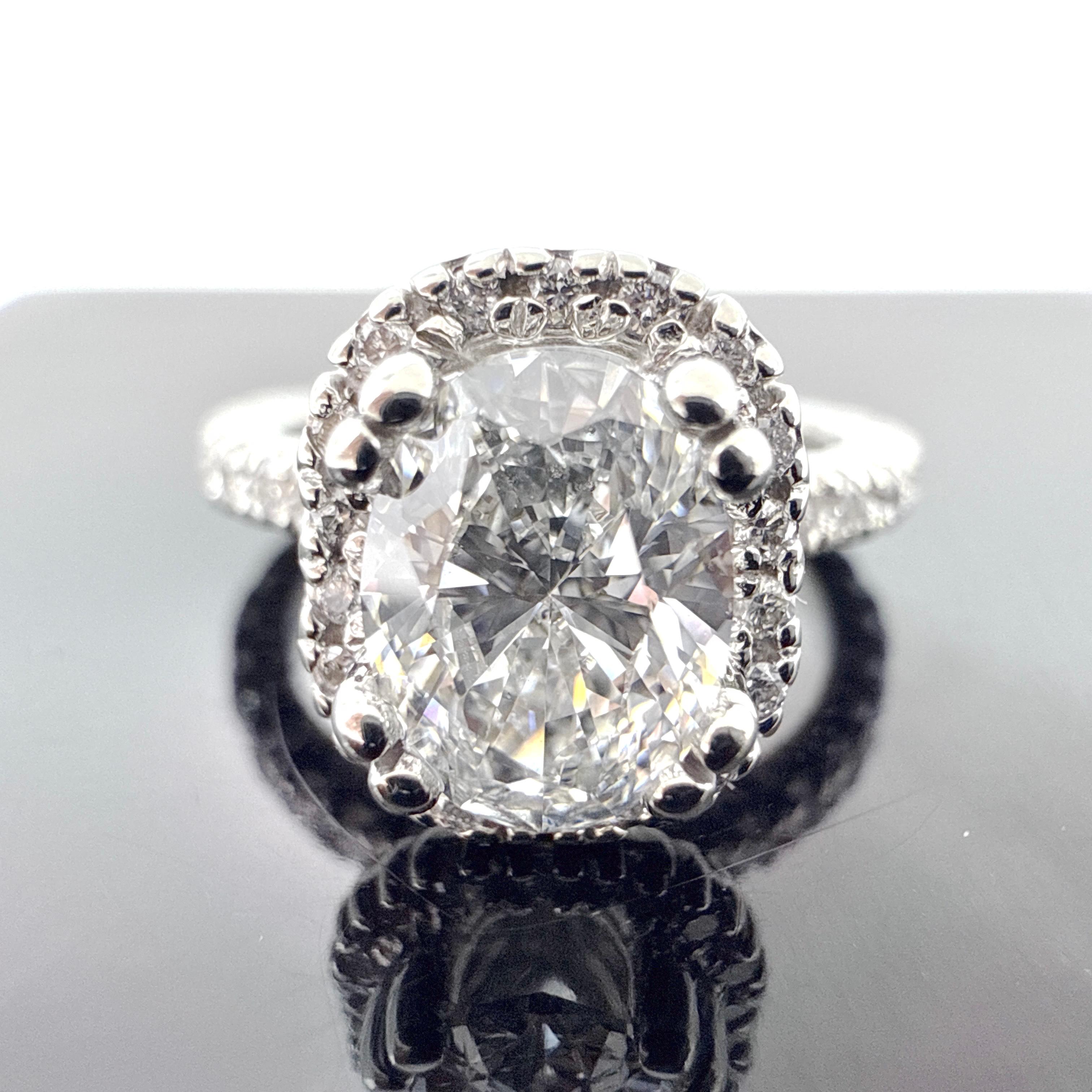 Questo anello di fidanzamento in oro bianco 18 carati è fuso in cera e rifinito a mano. La fascia misura 2,00 mm di larghezza alla sommità delle spalle e si assottiglia a 1,75 mm alla base del gambo. Il design è caratterizzato da un piano a forma di