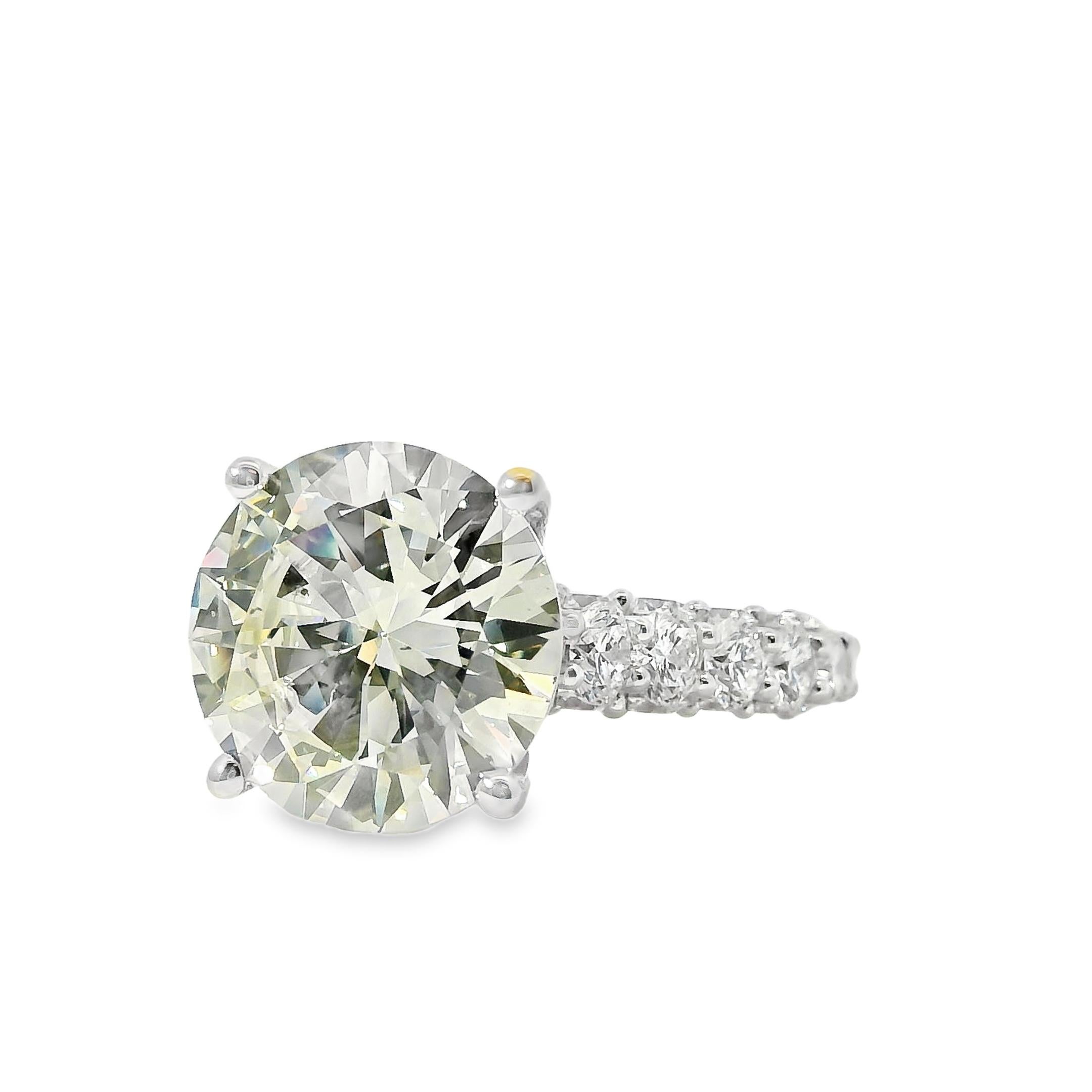 Este exquisito anillo solitario de oro blanco de 18 quilates exhibe un impresionante diamante natural redondo de talla brillante, certificado por el GIA por su excepcional calidad. El diamante central, con un peso aproximado de 5,07 quilates, tiene