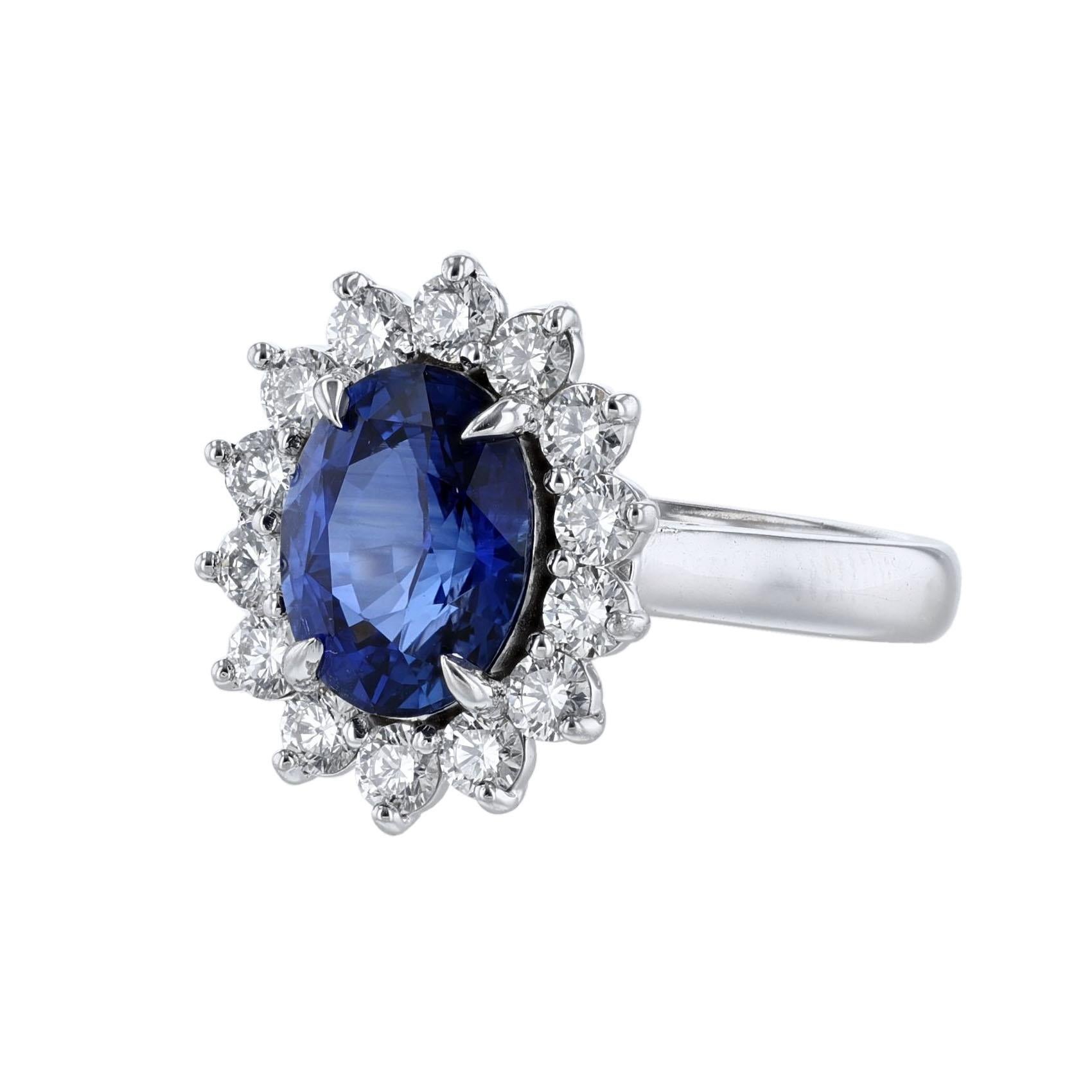 This ring is in 18K white gold. It features 1 oval-cut blue sapphire weighing 3.03. The stone is GIA certified with GIA 6183650942. It also features 14 round cut diamonds weighing 0.81 carats. With a color grade (H) and clarity grade (SI2). All