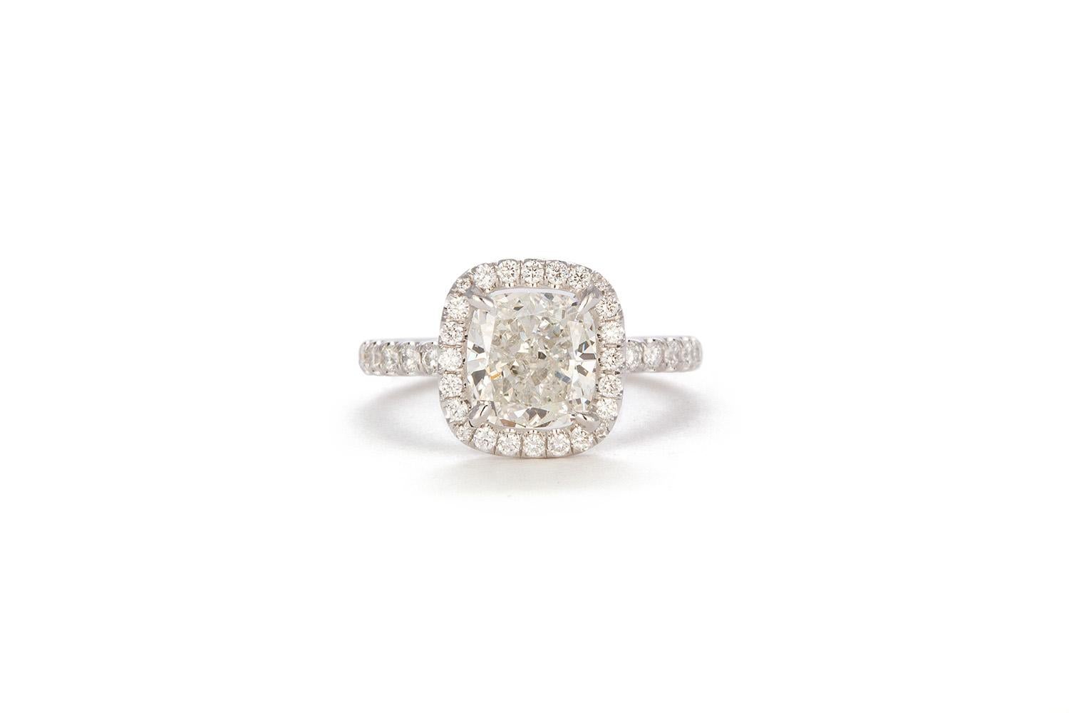 We are very pleased to present this remarkable 18k White Gold GIA Certified Cushion Cut Diamond Halo Engagement Ring. This stunning ring features a GIA Certified 2.01ct G/SI1 Cushion Cut Diamond set in a 18k white gold halo ring accented by 0.82ctw