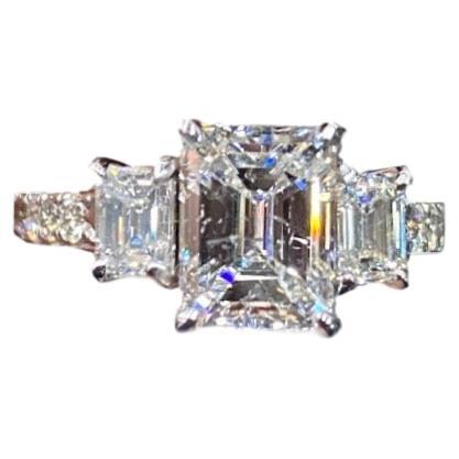 DeKara Design Collection

Metal- 18K White Gold, .750.

Size- 6 1/2

Stones-GIA Certified Emerald Cut Diamond E Color SI2 Clarity 2.00 Carats, Two GIA Certified Emerald Cut Diamonds, E Color SI1 Clarity 0.30 Carats, E Color SI1 Clarity 0.32 Carats,