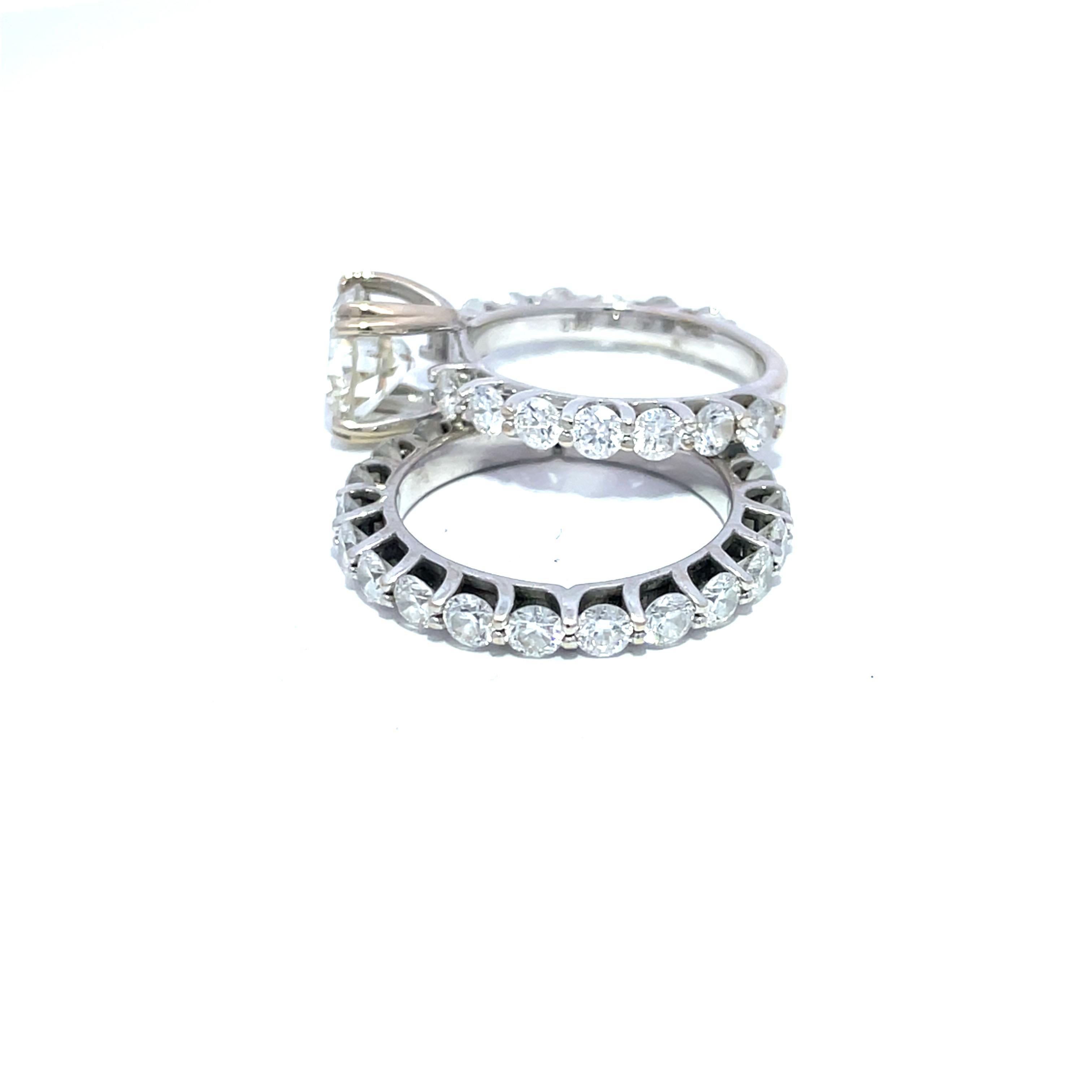 Rehaussez votre histoire d'amour avec cet exquis ensemble de mariage comprenant deux superbes bagues de fiançailles en diamant, méticuleusement fabriquées dans un luxueux or blanc 18 carats. La première bague est un élégant anneau d'éternité orné