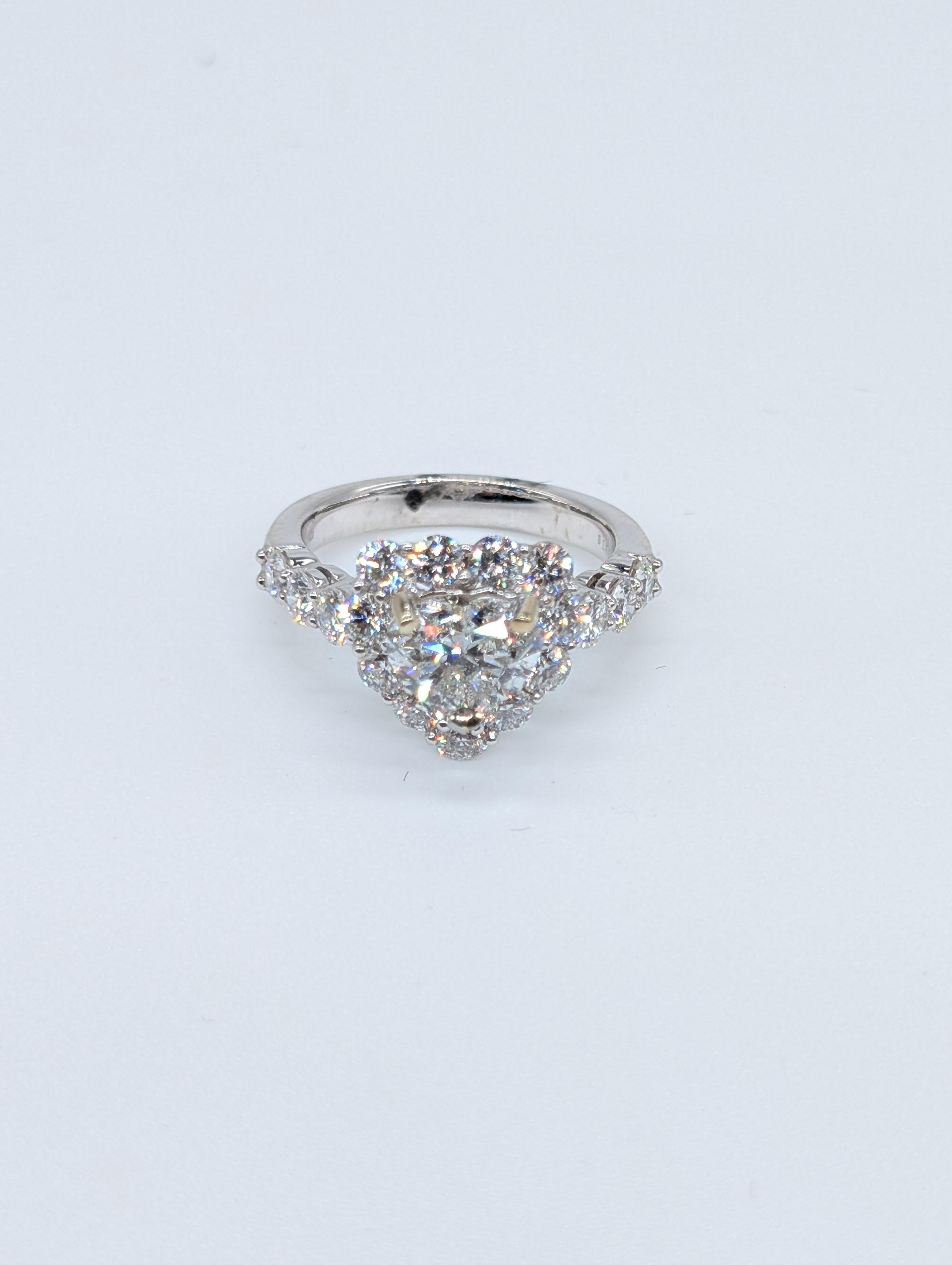 Cette exquise bague de fiançailles en or blanc 18 carats met en valeur un superbe diamant en forme de cœur de 1,51 carat certifié par le GIA, de couleur F et de pureté SI1, garantissant une brillance et une pureté exceptionnelles. Le diamant est