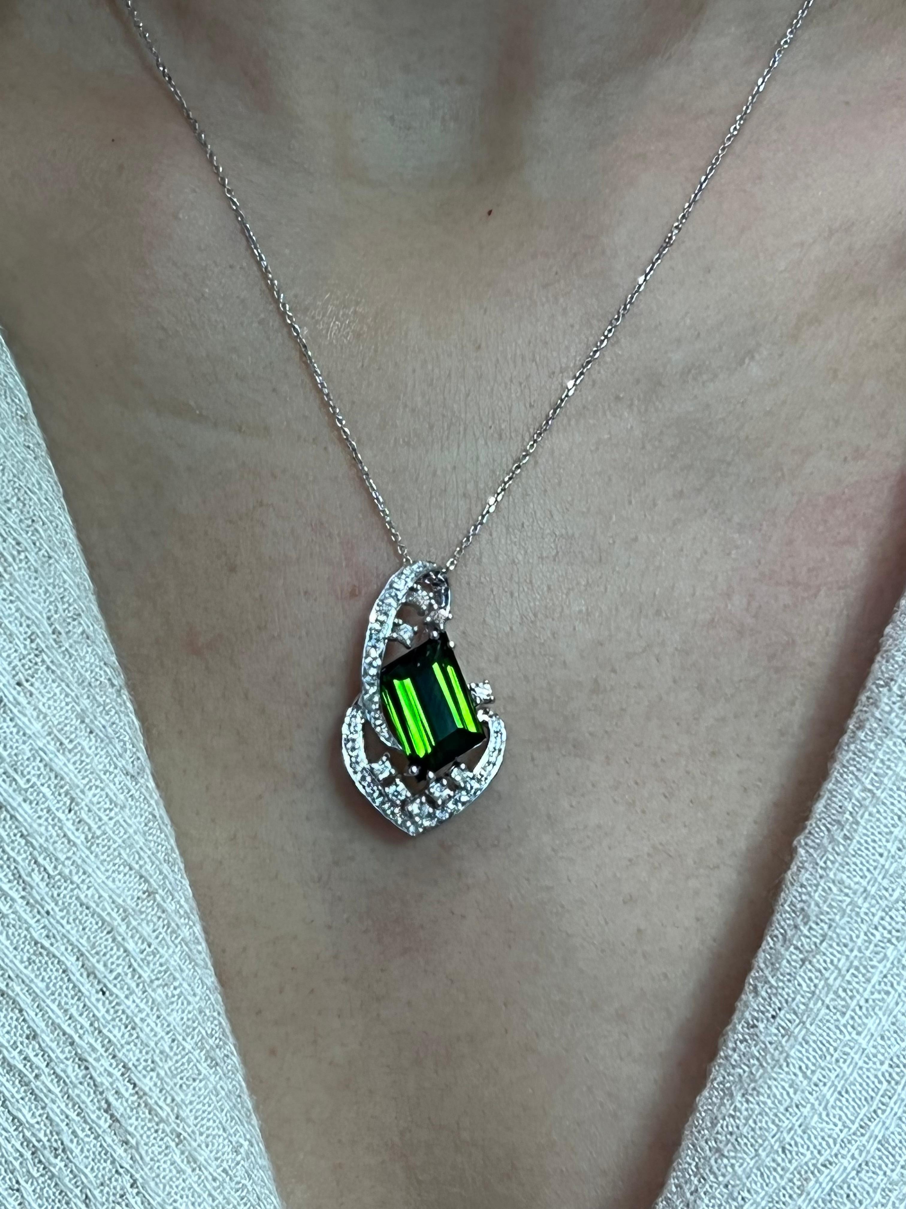 Please check out the HD video. This is a versatile piece of jewelry. You can wear this pendant dressed up or down. The green tourmaline pendant is made of 18k white gold and diamonds. There is one larger green tourmaline 5.43cts and 38 diamonds