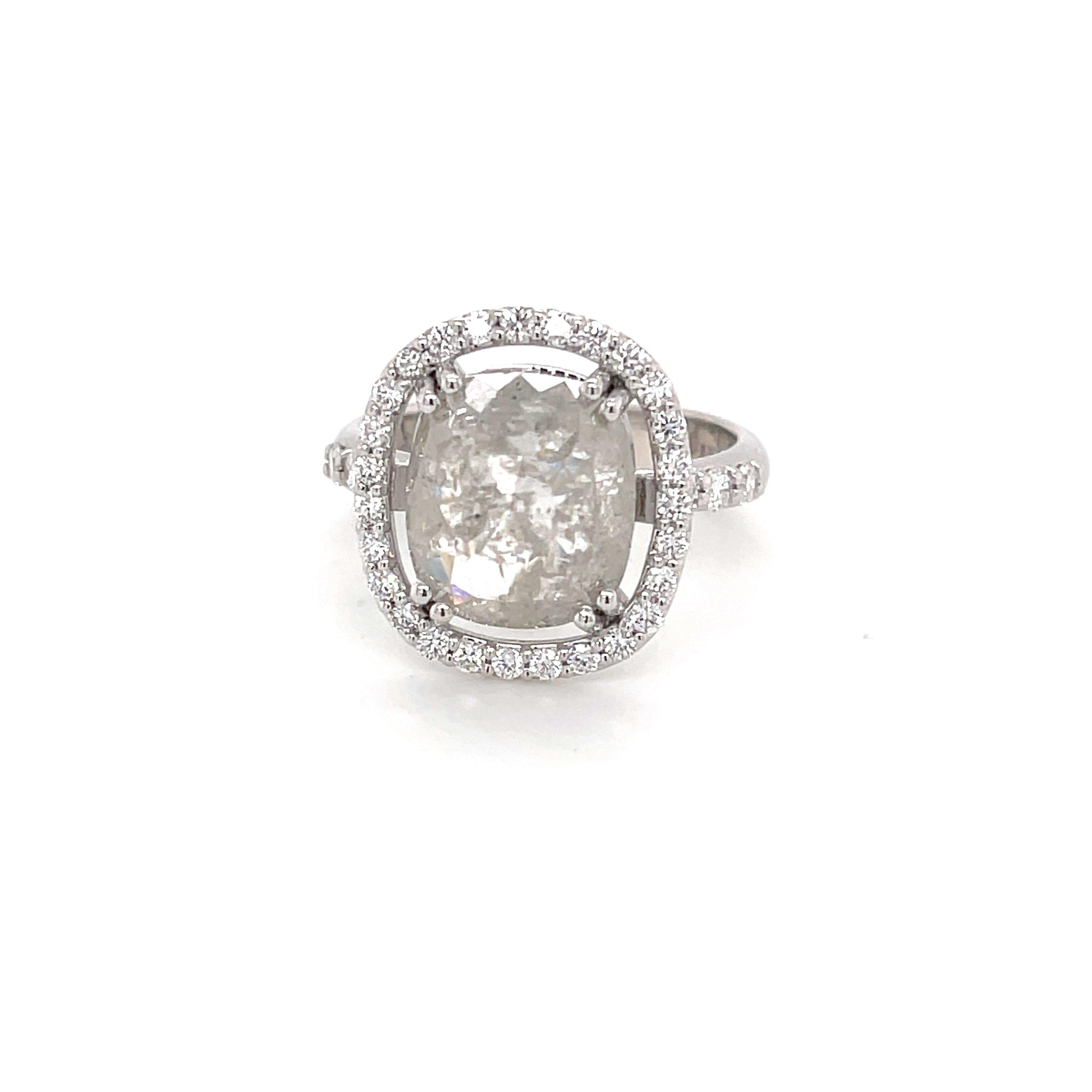 An 18k white gold ring set with one 4.33 carat cushion rose cut grey diamond, with .457 carats of white round diamonds. This ring was made and designed by llyn strong. Ring size 7.