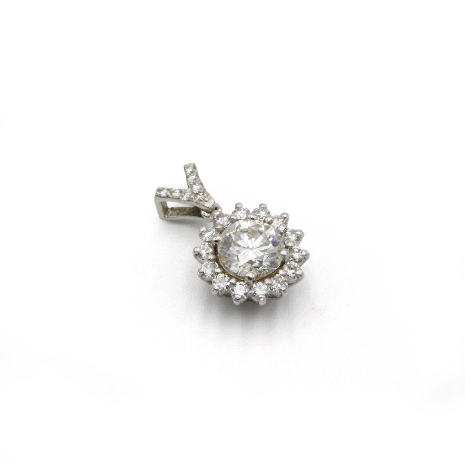 Eleva qualsiasi scollatura con questo squisito ciondolo solitario a forma di aureola realizzato in oro bianco 18 K (750‰). Il cuore è costituito da un diamante taglio brillante di 1,05 carati di colore G e caratura SI, il cui fuoco vivace è