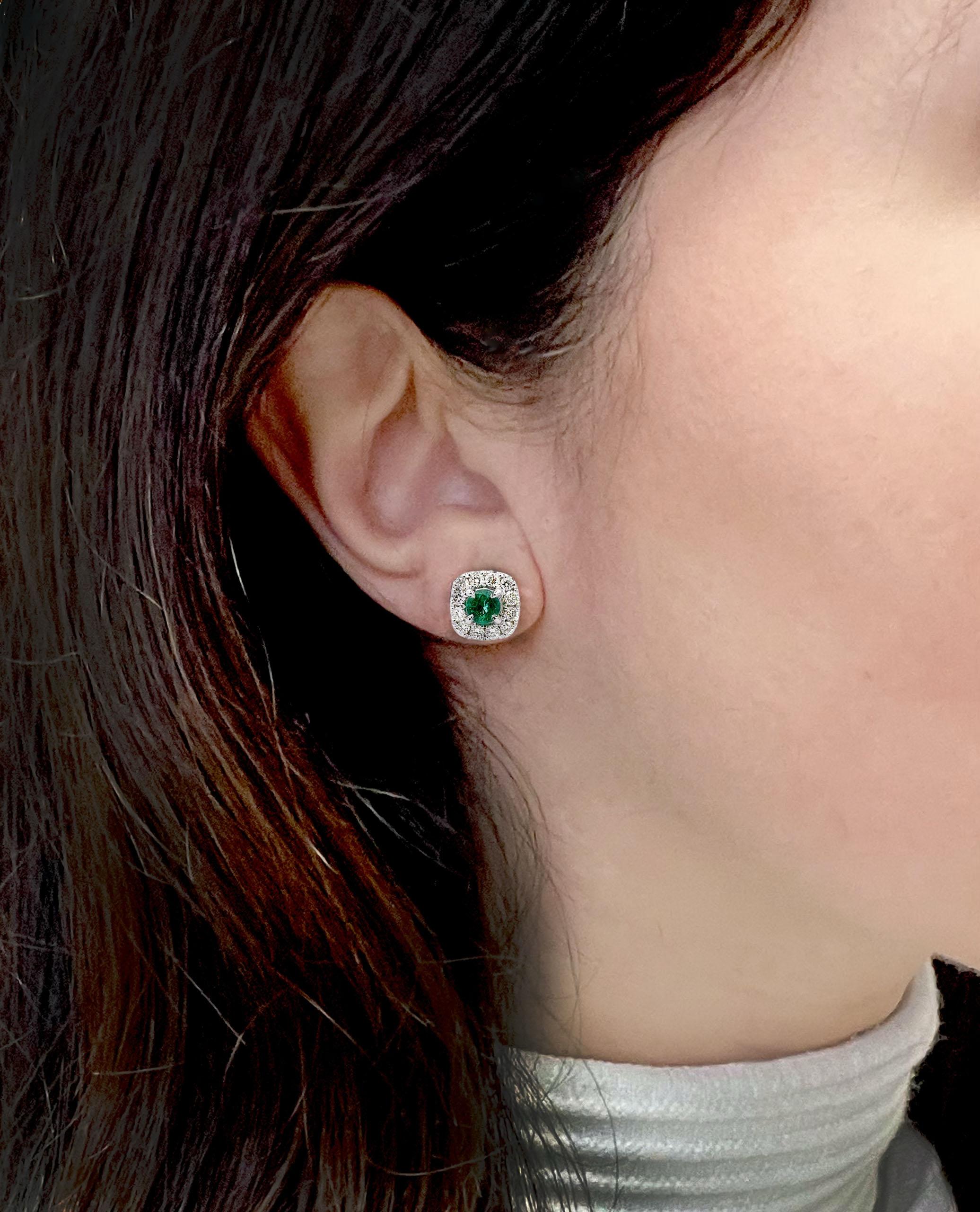 18K white gold stud earrings with two round faceted emeralds 0.70 carats total weight and 24 round faceted diamonds 0.71 carats total weight.

- Diamonds are H color, SI1/SI2 clarity.
- Push back closure.
- Emeralds measure approximately 4.6mm each.