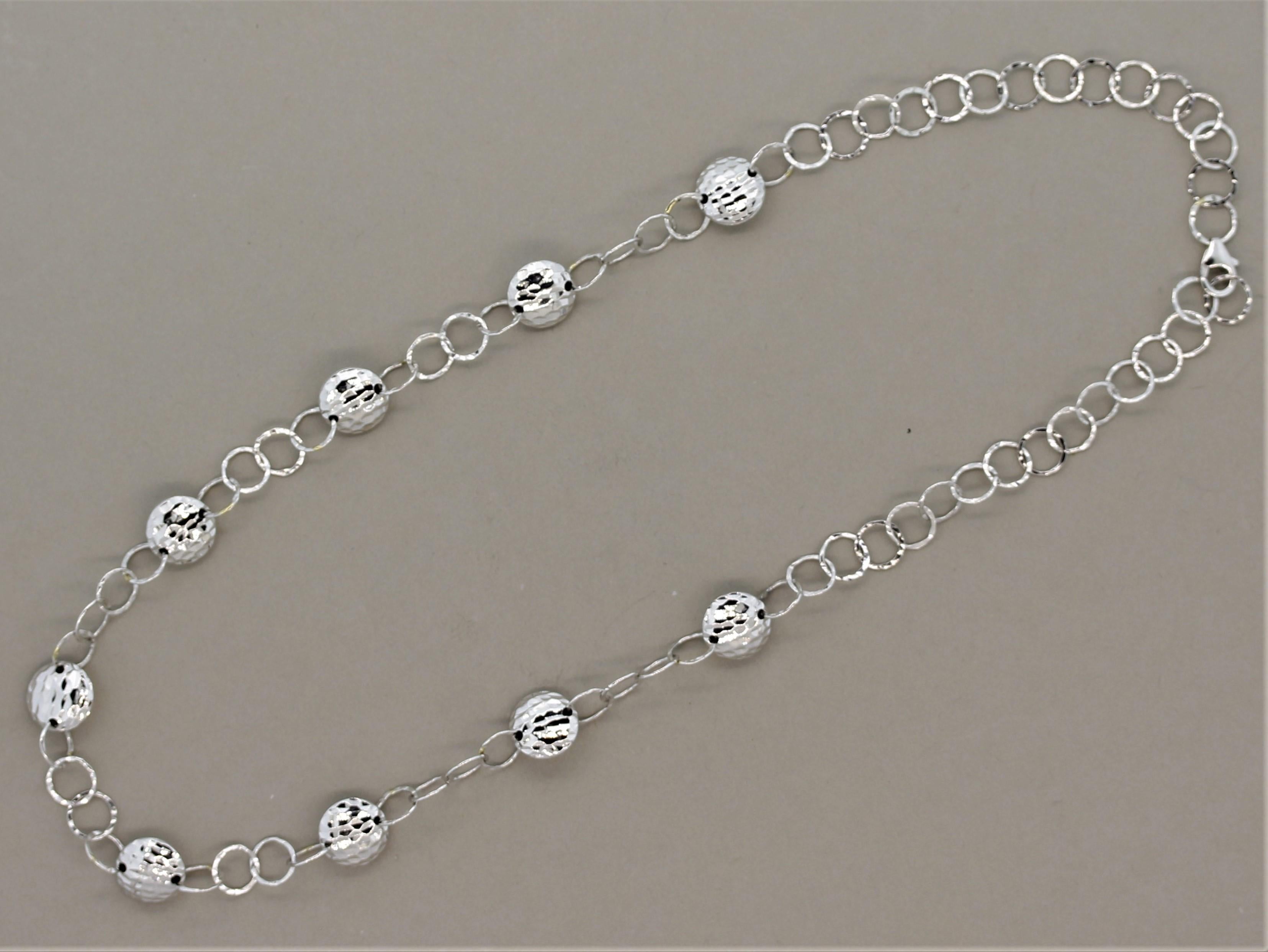 A simple yet elegant chain necklace. It is made in 18k white gold and hand worked and hammered to form rounded gold accents. They have a textured finish and a high polish giving the piece a bright shining look. Lightweight and easy to wear.

Length: