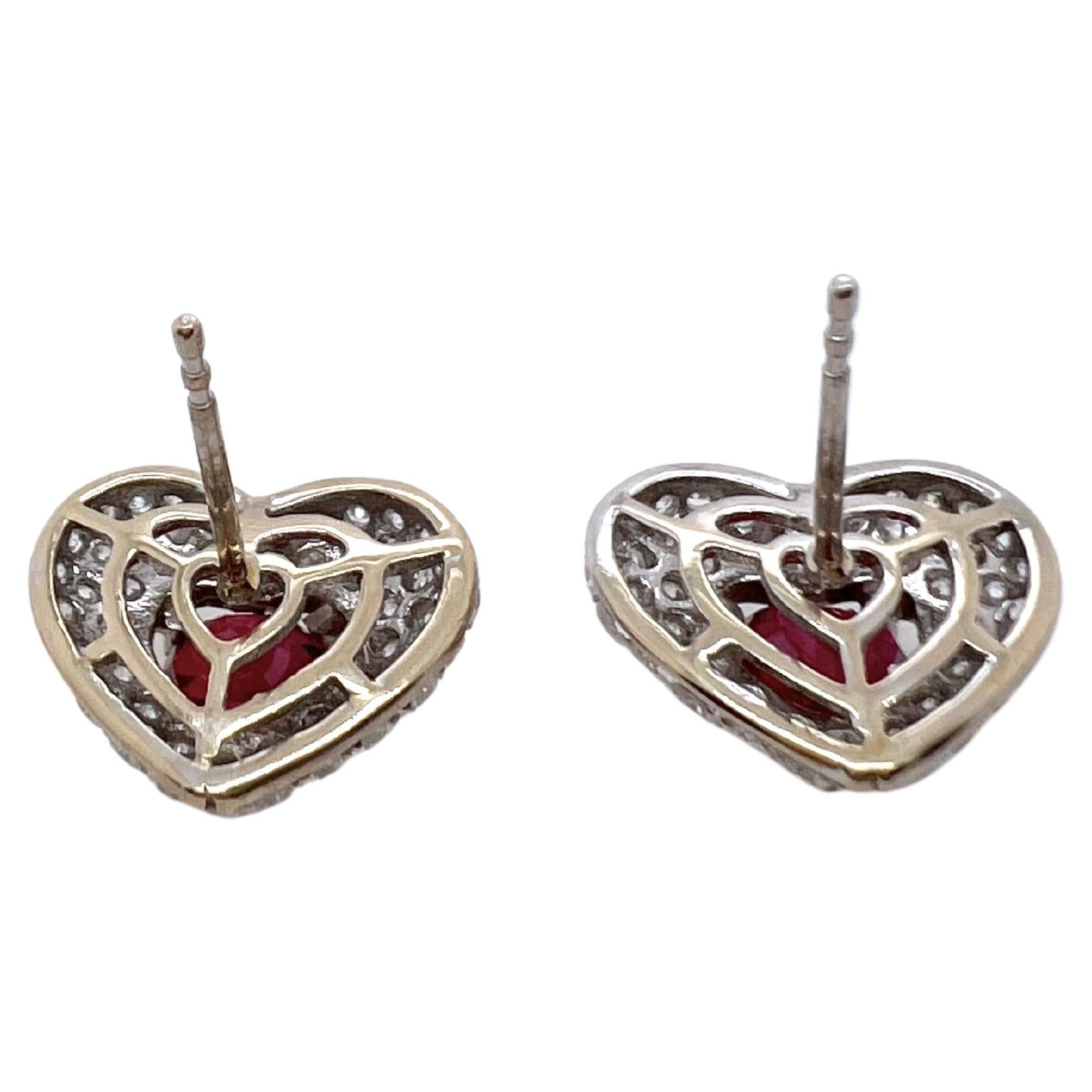 This gorgeous pair of heart shaped rubies are set in a custom made 18k white gold diamond setting.  The heart shaped frame further accentuates the beautiful heart shaped rubies.  Definitely different than your classic studs, that will grasp