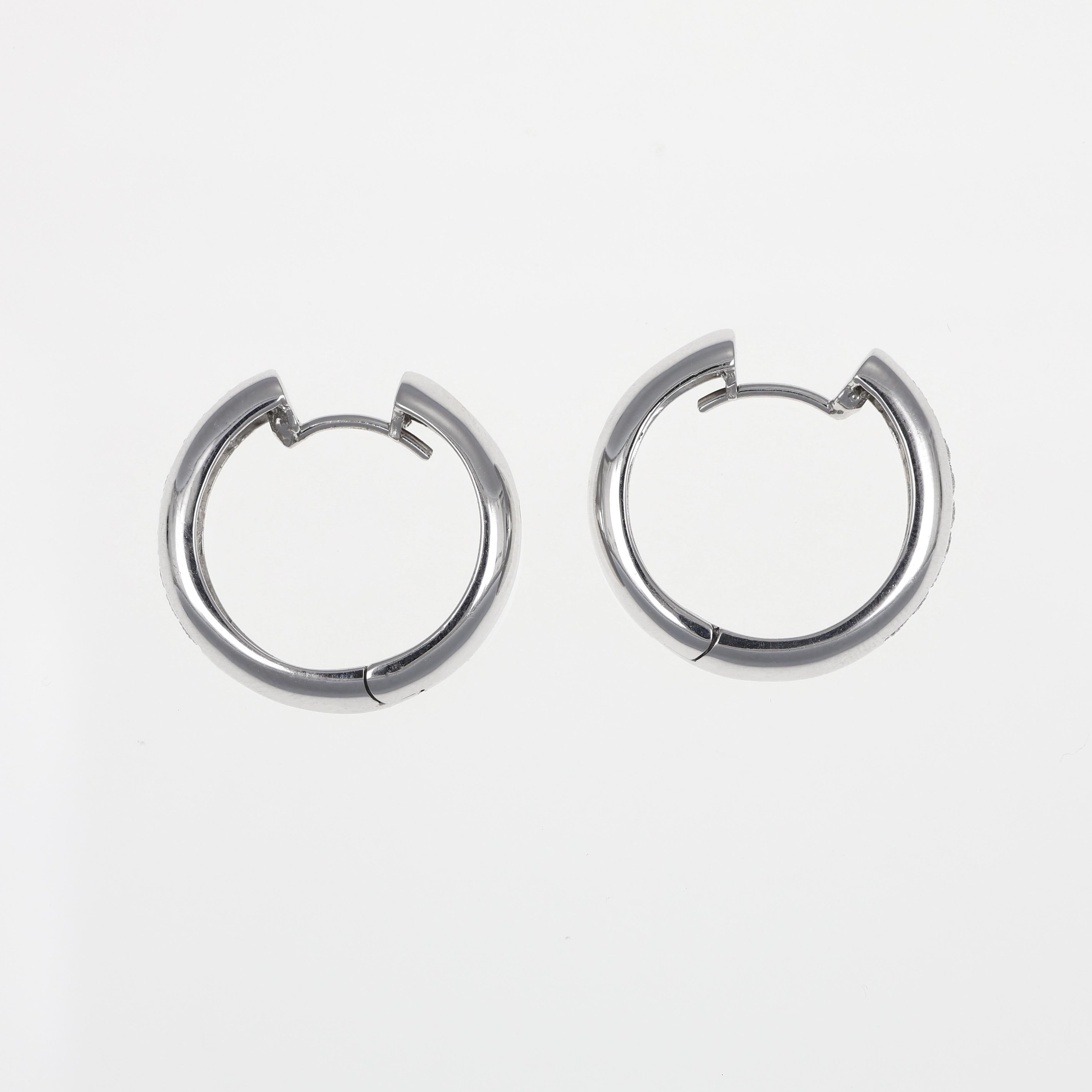 These timeless hoop earrings are crafted in 18K white gold, featuring a sleek design enhanced by a single row of brilliant-cut diamonds totaling 0.32 carats. With their polished finish and understated elegance, these earrings are ideal for both