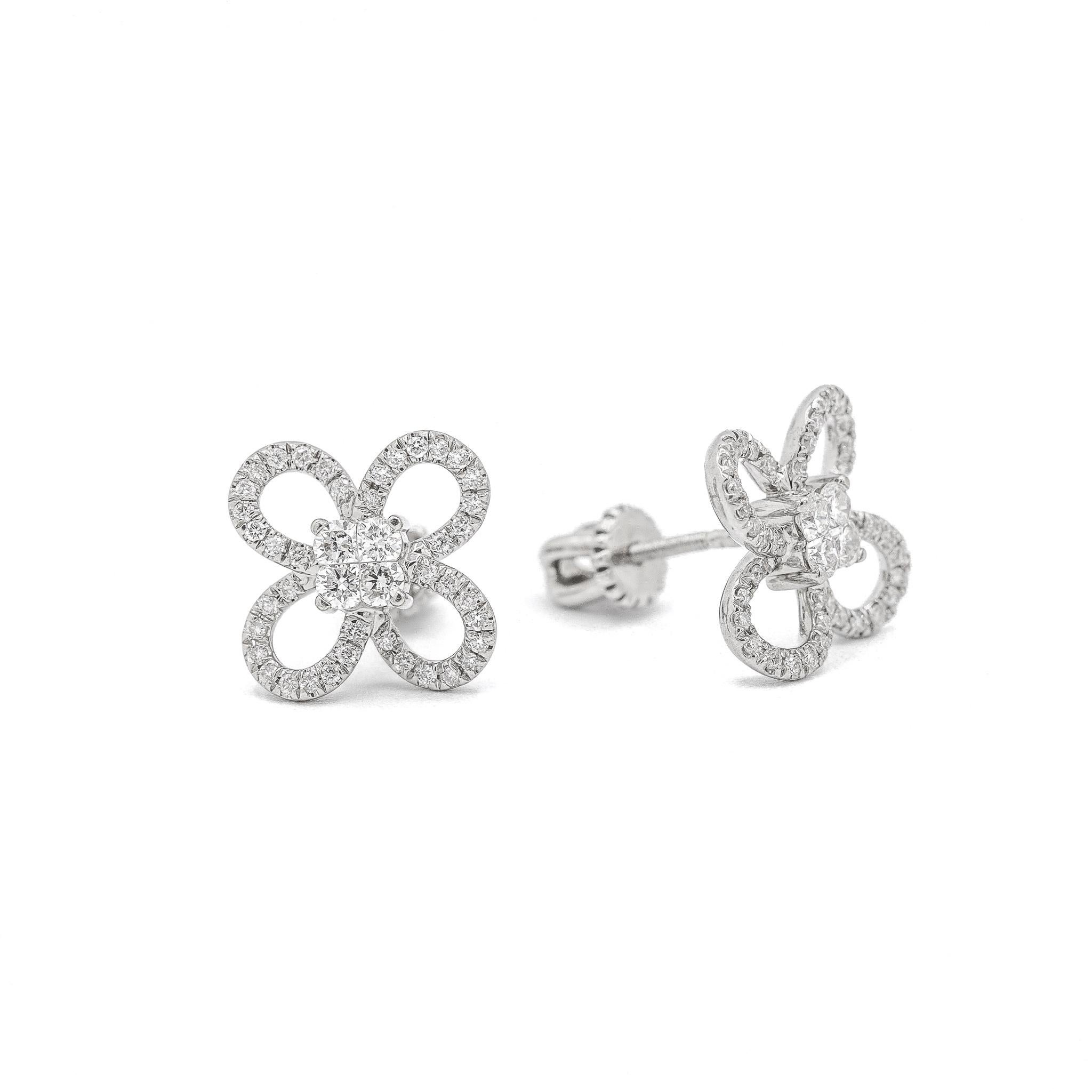 One pair of lady's custom made polished 18K white gold, diamond stud, cluster, halo earrings with screw backs. The earrings measure approximately 0.50 inches in length by 12.18mm tapering to 8.22mm in width and weigh a total of 4.30 grams. In