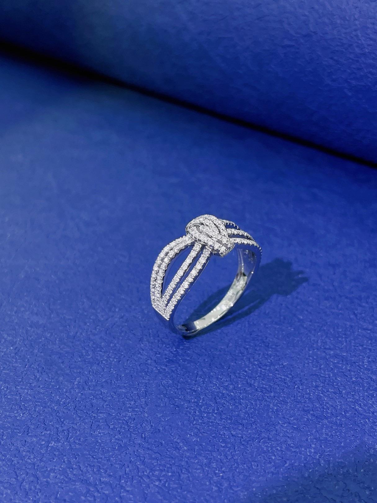 A masterpiece of nature-inspired luxury, this intricately crafted 18K white gold band ring features a symbolic knot and hollow pattern, adorned with 0.60ct of brilliant natural diamonds. Representing unity, strength, and eternal elegance, the