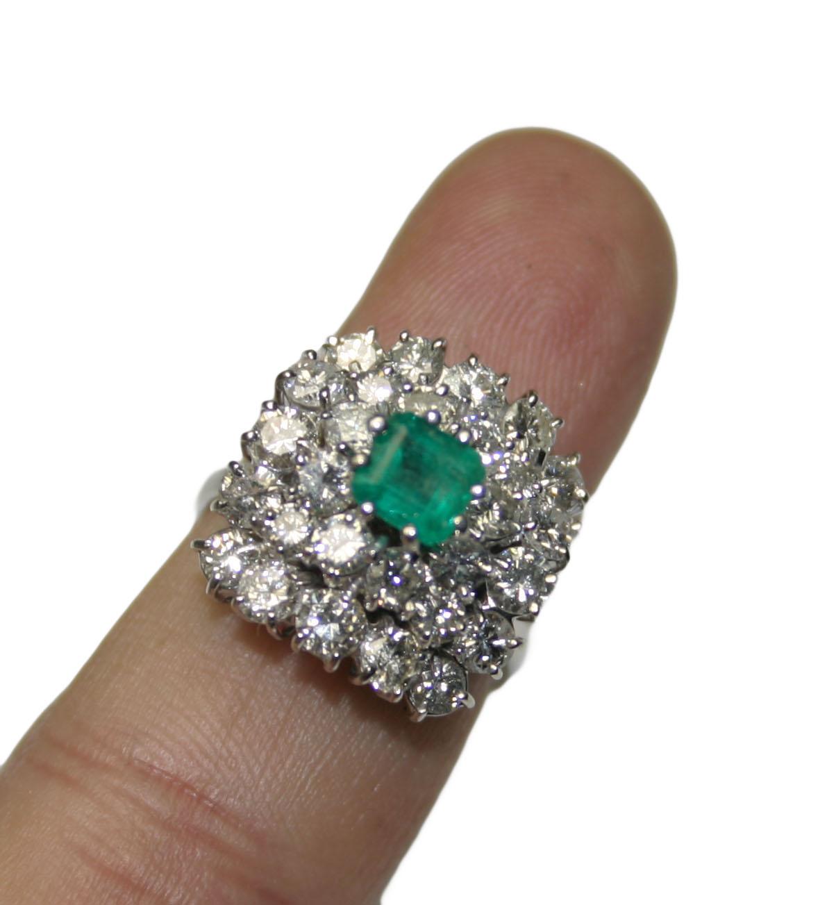 18k White Gold Diamond and Colombian Emerald Ring.
The center stone is a 5x5mm Colombian emerald with an approximate weight of 0.75 carats.
The emerald is surrounded by 28 round brilliant diamonds with a total weight of 2.50ct and SI1 clarity with I