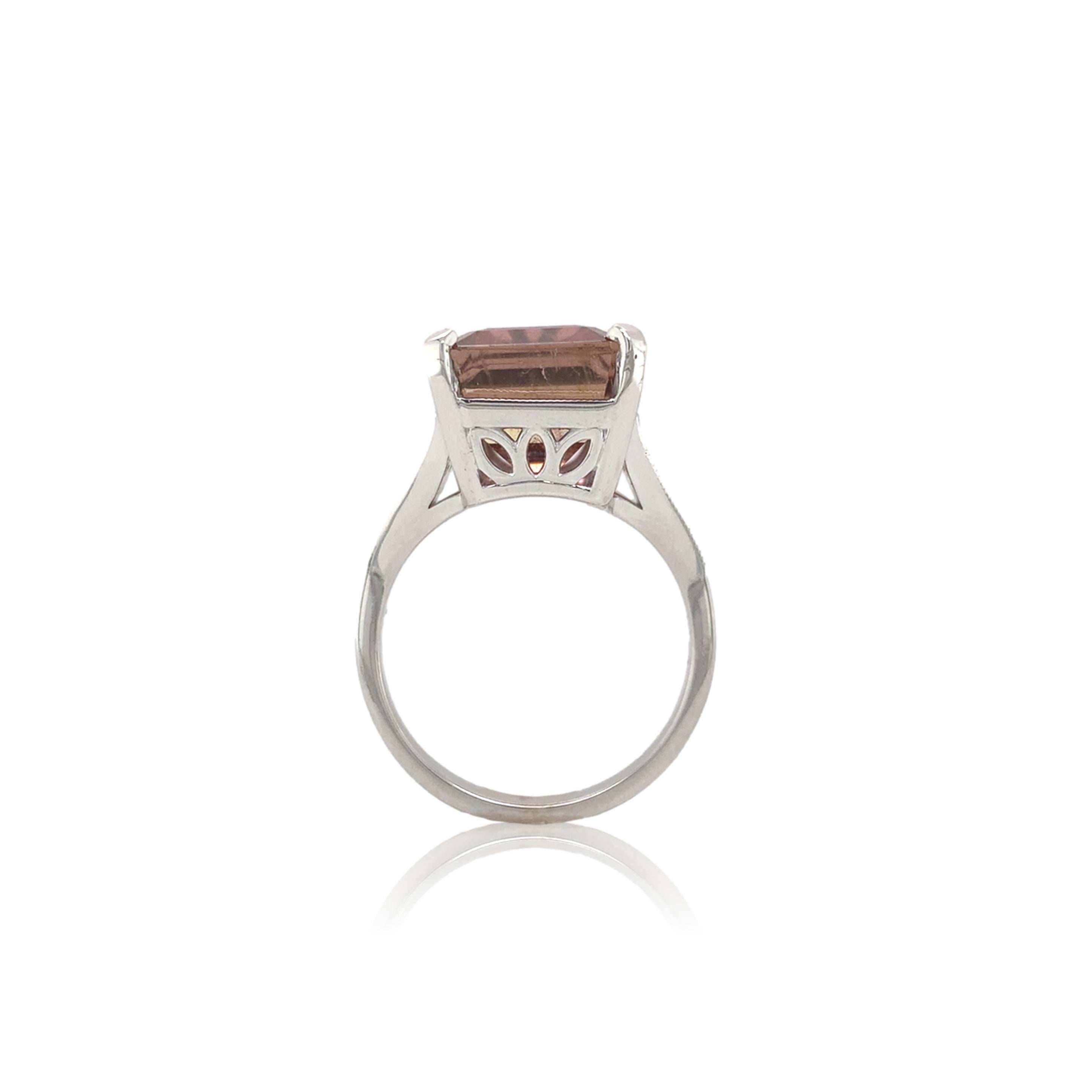 18k white gold ring featuring a large genuine earth mined rubellite tourmaline weighing 9.93 carats.  The tourmaline is a emerald cut with medium raspberry-pink color.  The tourmaline measures about 14mm x 10.3mm.  There are 24 small round brilliant