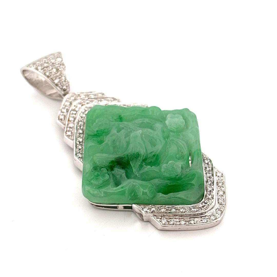 Questo elegante ciondolo vintage presenta una placca di giada intagliata a mano e incastonata in un lussuoso oro bianco 18 carati. La ricca giada verde presenta intricati motivi floreali e fogliati, che evocano un'arte e un'eredità culturale senza