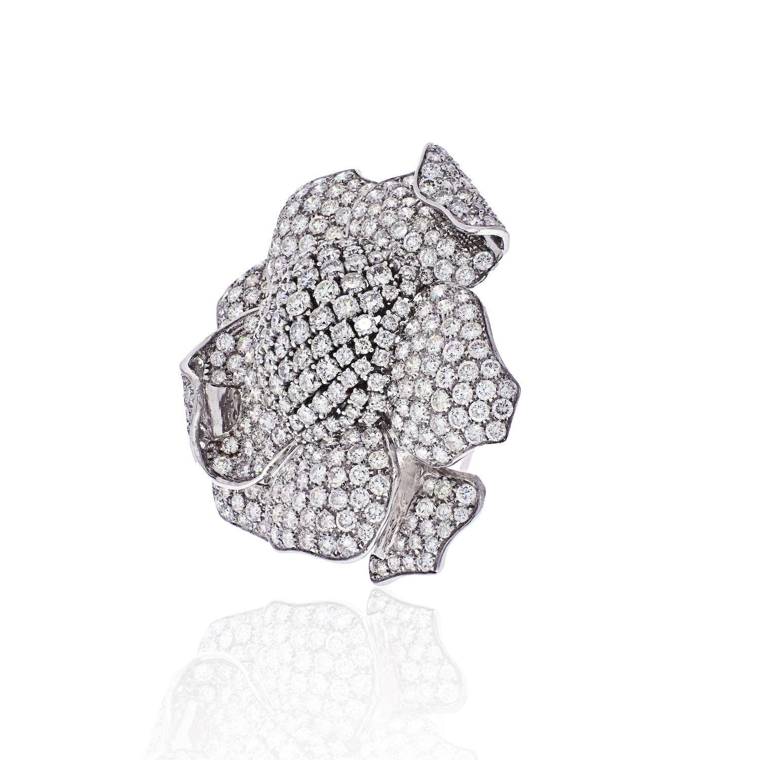 Stunning flower brooch encrusted with numerous round cut diamonds crafted in 18k white gold. It has the perfect balance between bold and classy making it the ideal evening statement piece. It is 2.5 inches wide. 
Diamond Carat Weight: 35cttw