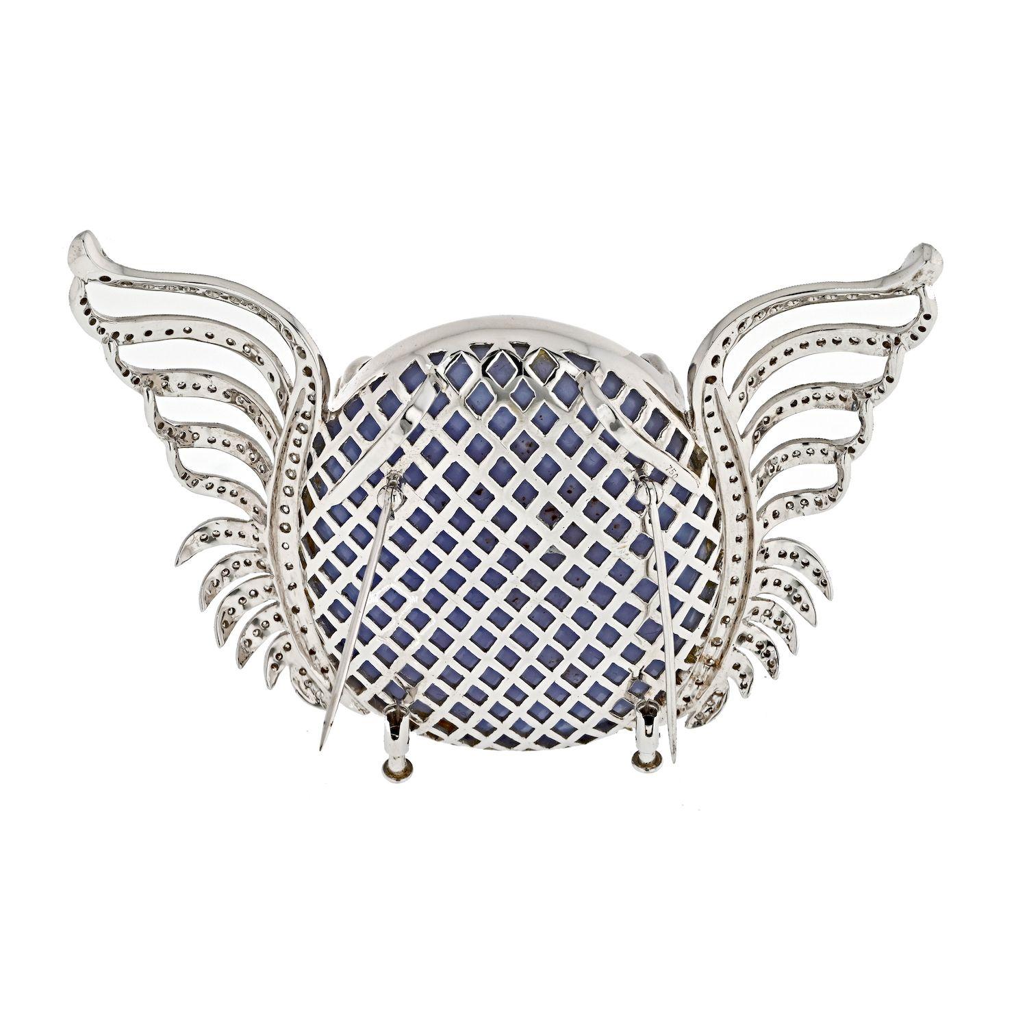 Discover the epitome of bespoke craftsmanship with this exquisite custom-made brooch, a fusion of elegance and versatility. Crafted in 18k white gold, the centerpiece boasts an oval cabochon cut quartz in a captivating light blue hue, measuring