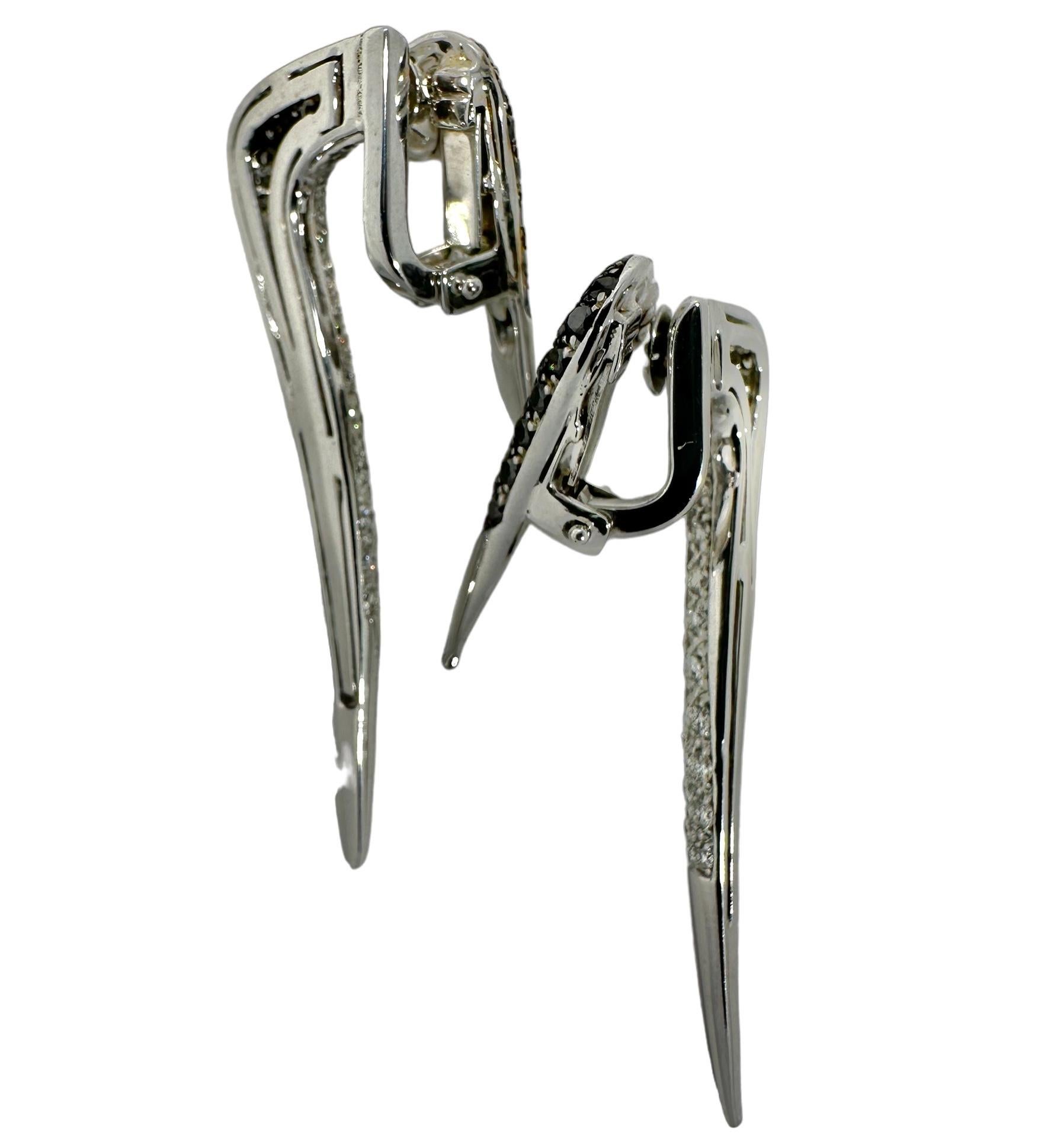 This scintillating pair of 18k white gold and diamond icicle earrings are worn in front and behind the ear. They give the illusion that they actually pierce the wearer's ears, but in fact they do not. They simply clip firmly onto the earlobe. Panels