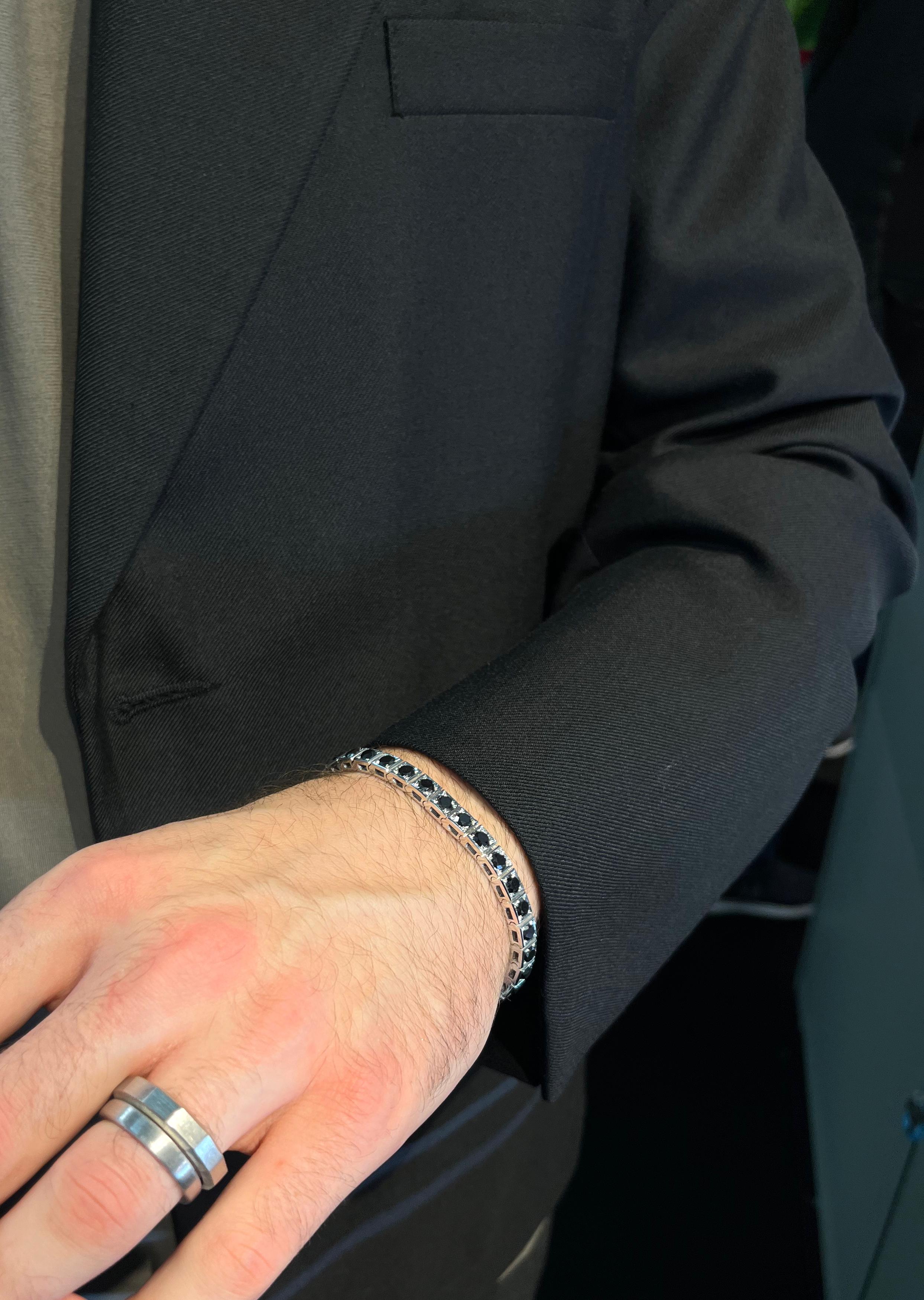 Ce bracelet pour homme brillant et épuré en or blanc 18k incrusté de diamants noirs est une pièce sophistiquée qui attire l'attention et éblouira de jour comme de nuit.

Poids : 14,50 carats