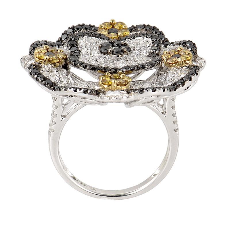 This ring is opulent and shines with diamonds. This fabulous ring is made of 18K white gold and boasts a flower shaped accent. The flower is set with black and white diamonds and is accented by four small flowers made of yellow and black diamonds;