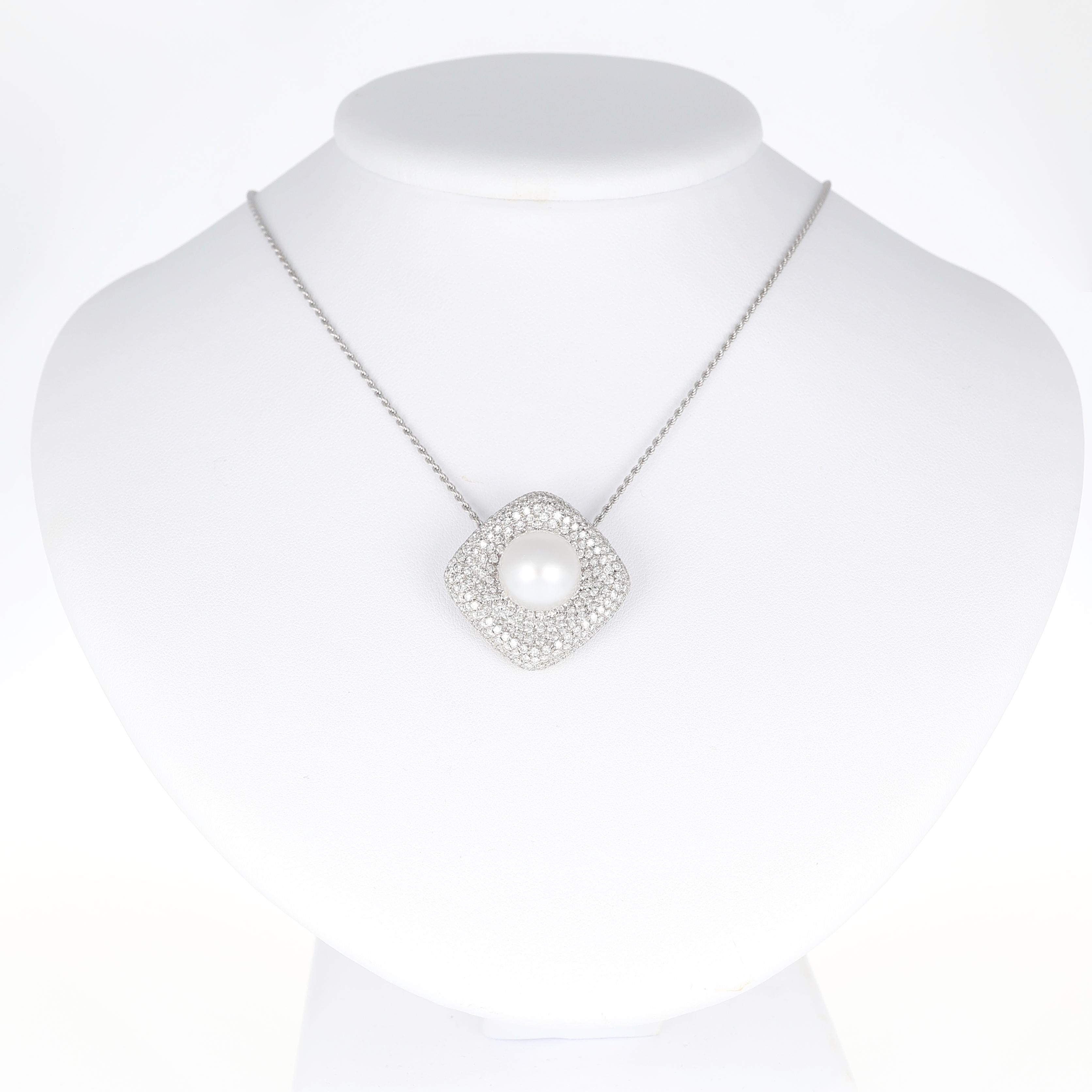 Raffinata composizione di brillantezza ed eleganza, questa collana in oro bianco 18 carati presenta un ciondolo a forma di cuscino completamente incrostato di diamanti incastonati a pavé per un totale di 3,90 carati. Al centro, una perla luminosa