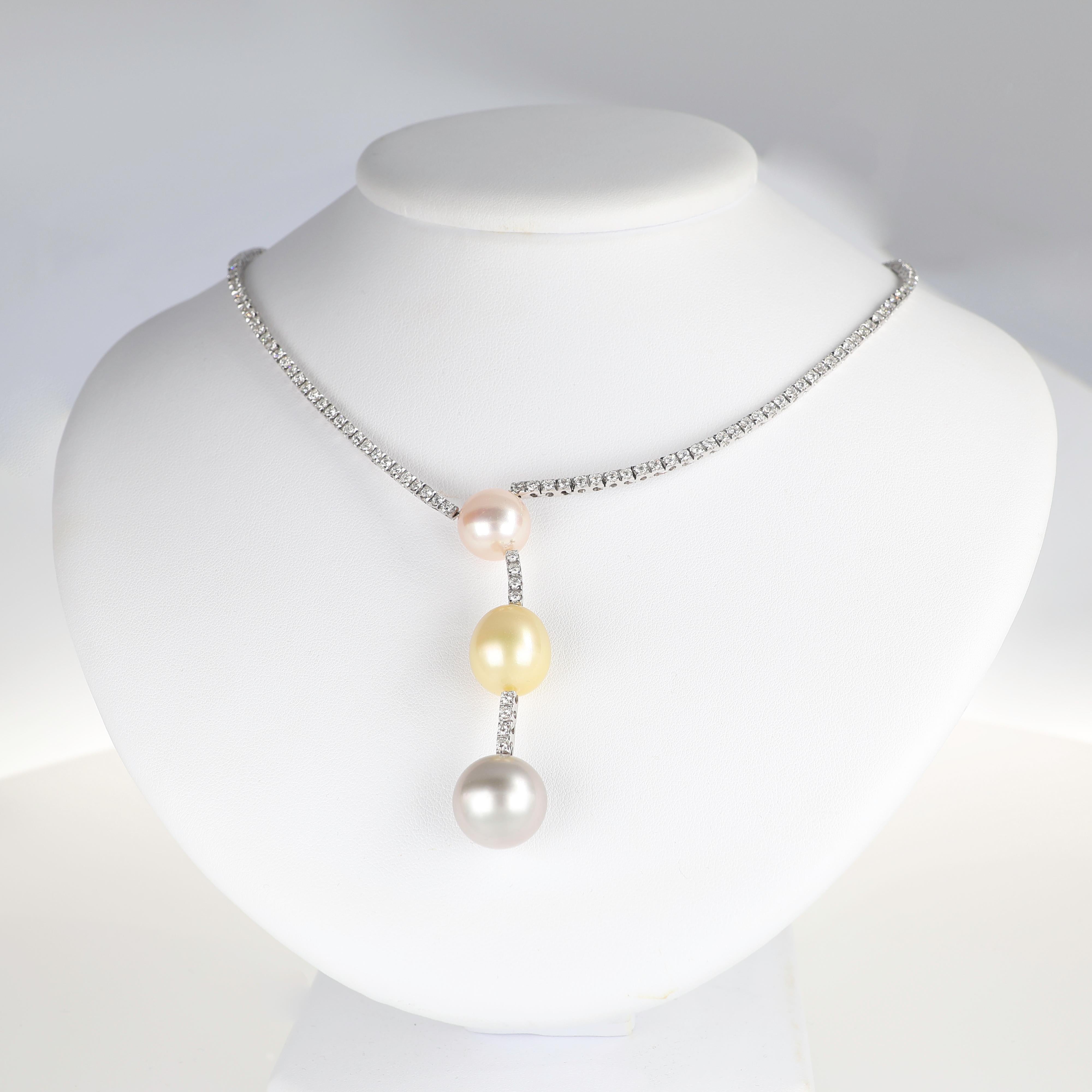 A refined composition of diamonds and pearls, this necklace embodies sophisticated elegance. Crafted in 18K white gold, the design features a delicate cascade of three natural pearls in soft gray, golden, and blush pink hues. The necklace is adorned