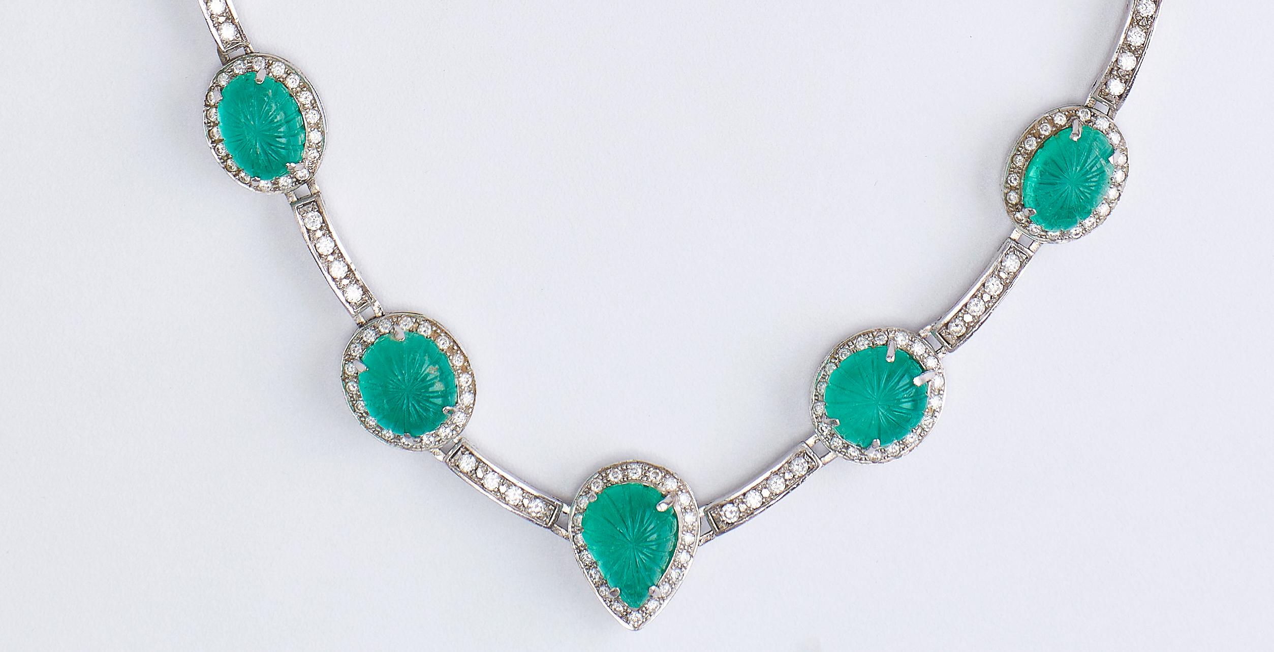 18k White Gold Necklace with Emeralds and Diamonds Certified
Stunning necklace, set with 9 emeralds Cabochon (Pear - Oval - Round) total 39.00 ct emerald. 
Each emerald is surrounded by diamonds and between every 2 stones there are 4 diamonds.
With