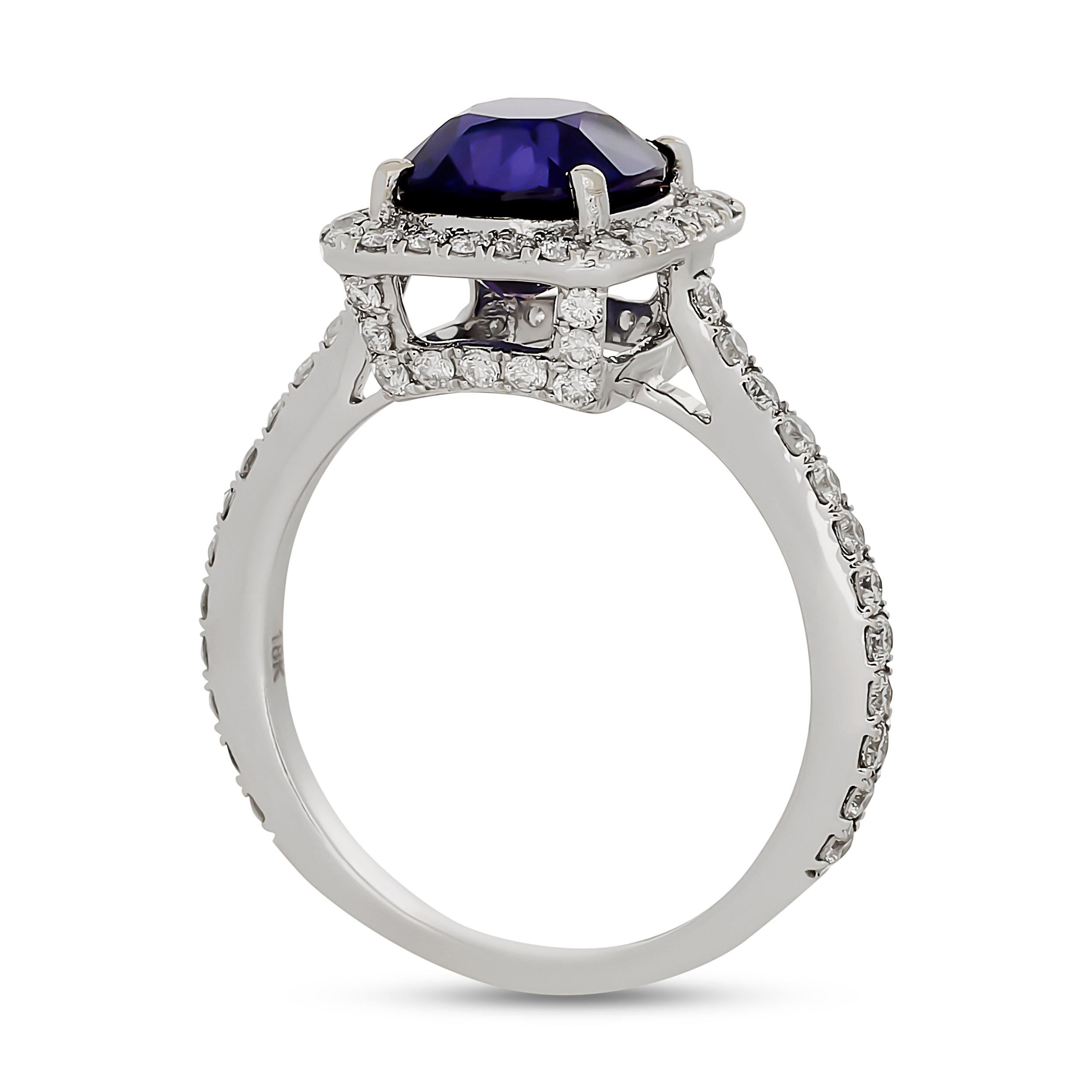 This striking ring features a vibrant cushion-cut color-change sapphire, encircled by a dazzling halo of pavé-set diamonds that extend down the shoulders of the white gold band.

The center cushion shape sapphire weighs approximately 2.94 carats,