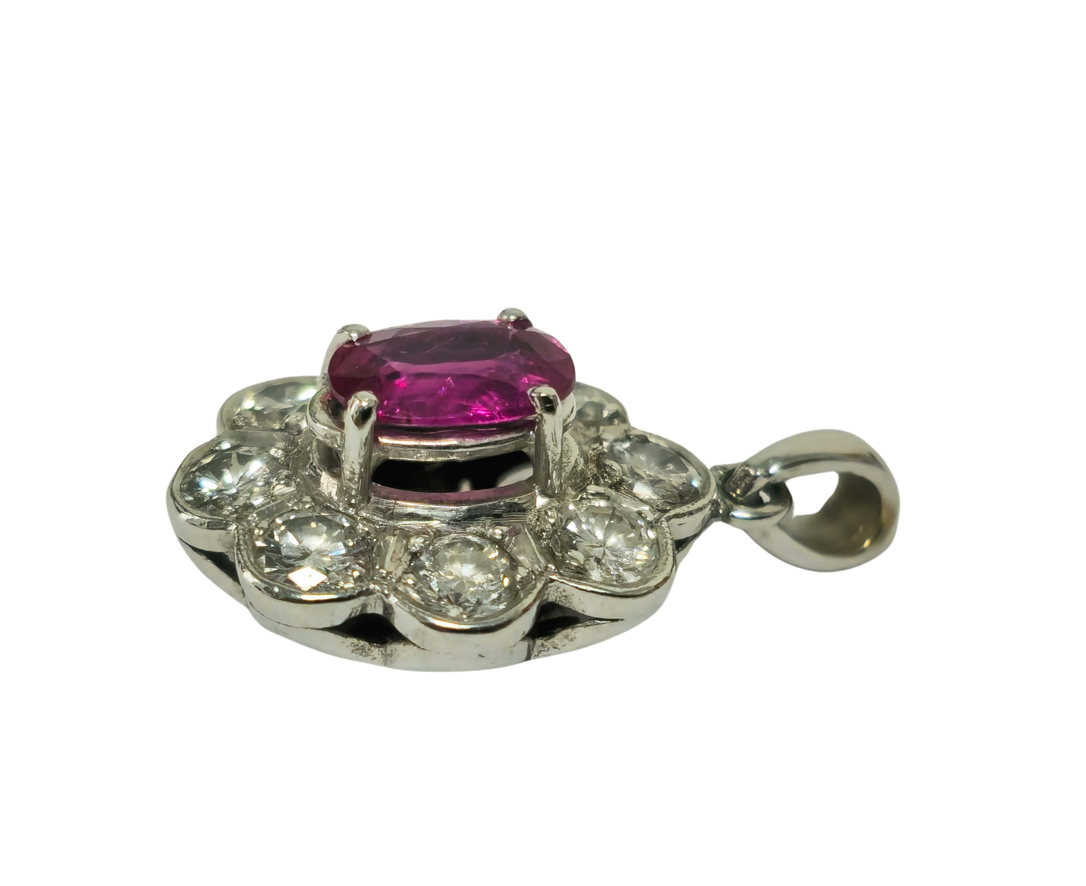 Réalisé en or blanc 18 carats, ce pendentif présente un design captivant avec un rubis sans chaleur de taille ovale, d'une beauté naturelle et d'une allure vibrante. Le rubis est entouré de diamants blancs brillants d'une qualité exceptionnelle,