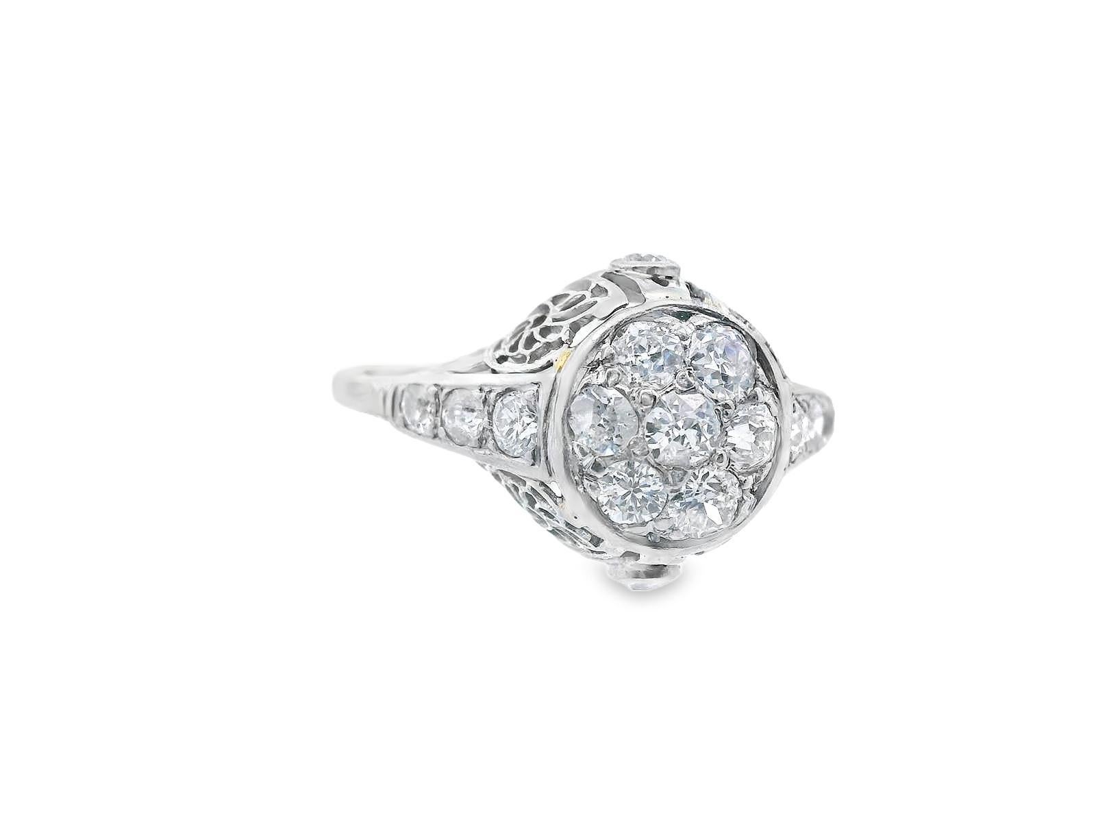 Cette bague à grappes de diamants en or blanc 18k est magnifique ! La bague comporte un total de 15 diamants blancs brillants de taille européenne ancienne, dont 7 sont regroupés pour former le centre, enchâssés dans un chaton en or blanc. Les côtés