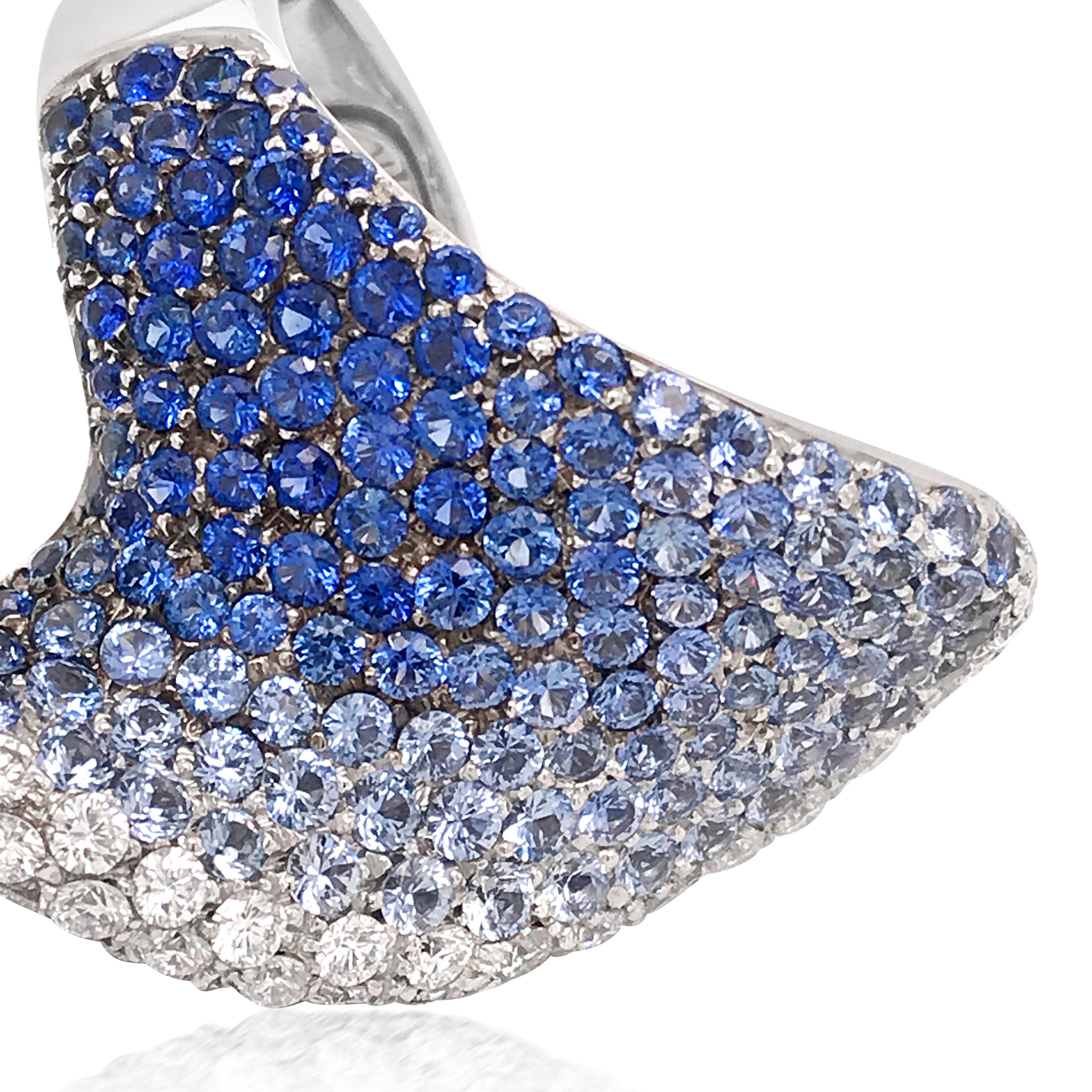This stylish ombre sapphire and diamond ring is crafted in 18K white gold, weighing 23.50 grams and measuring 43*24mm. It is perfectly designed as the 7.45-carat sapphires and 2.0-carat diamonds are set by their colors. The sapphires are graduated