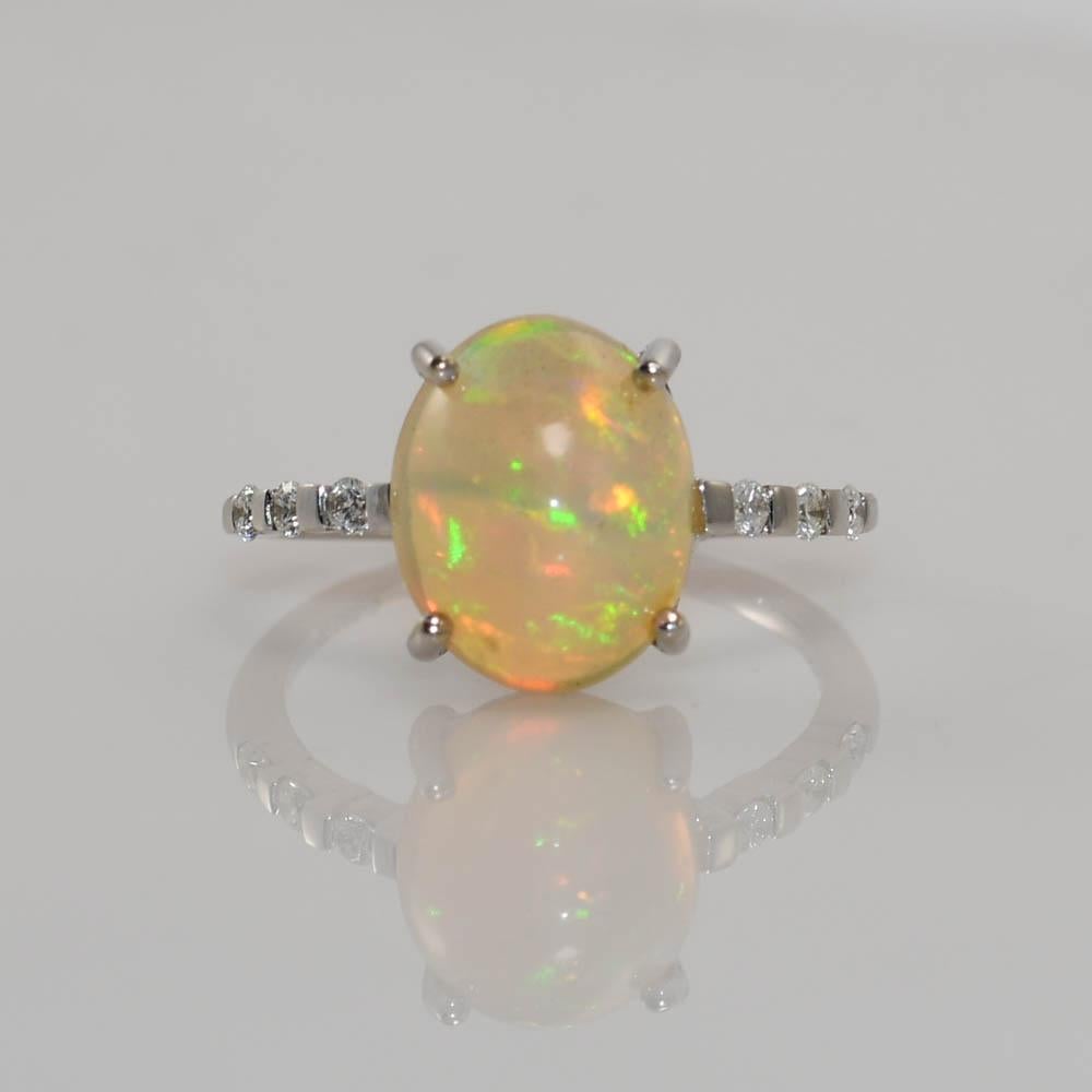 Ladies Ethiopian opal and diamond ring in 18k white gold setting.
Stamped 18k, 2.66, .128 and weighs 2.7 grams.
The high quality opal is 2.66 carats, solid chunk cut in a high dome.
Excellent colors from all angles, green, orange and some blue.
The