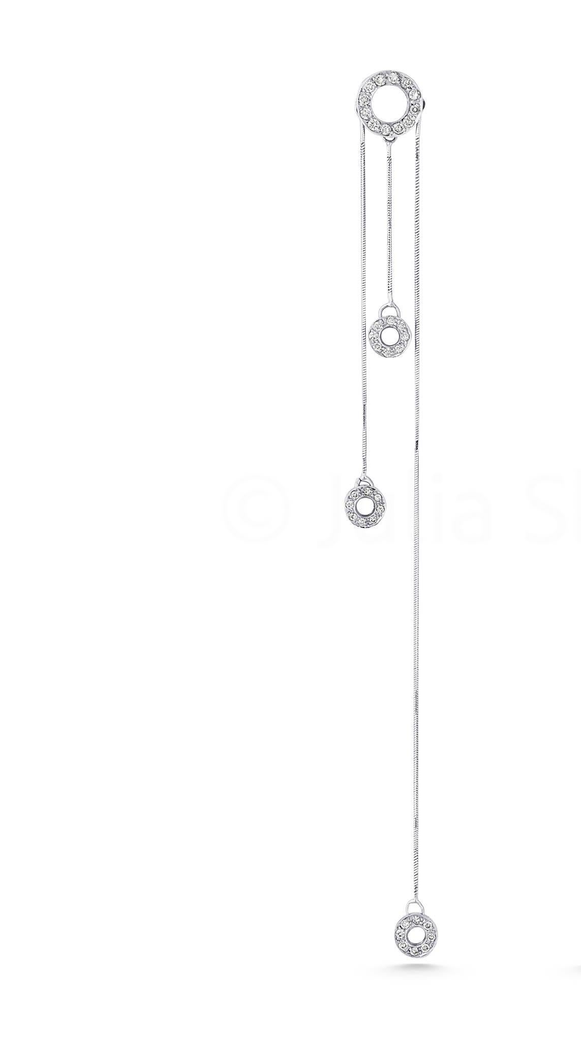 Réalisée en or blanc rayonnant et rehaussée de diamants étincelants, cette boucle d'oreille chandelier en forme de cercle ouvert est conçue pour celles qui osent être différentes. Un cercle audacieux ancre la pièce, avec trois cercles élégants en