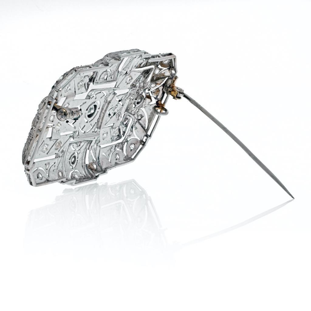 Realizzata negli anni '40, questa straordinaria spilla in oro bianco 18 carati ha una forma rettangolare aperta. Gli angoli morbidi sono impreziositi da diamanti di taglio rotondo e sono ulteriormente decorati con una lavorazione a grana fine. 
Peso