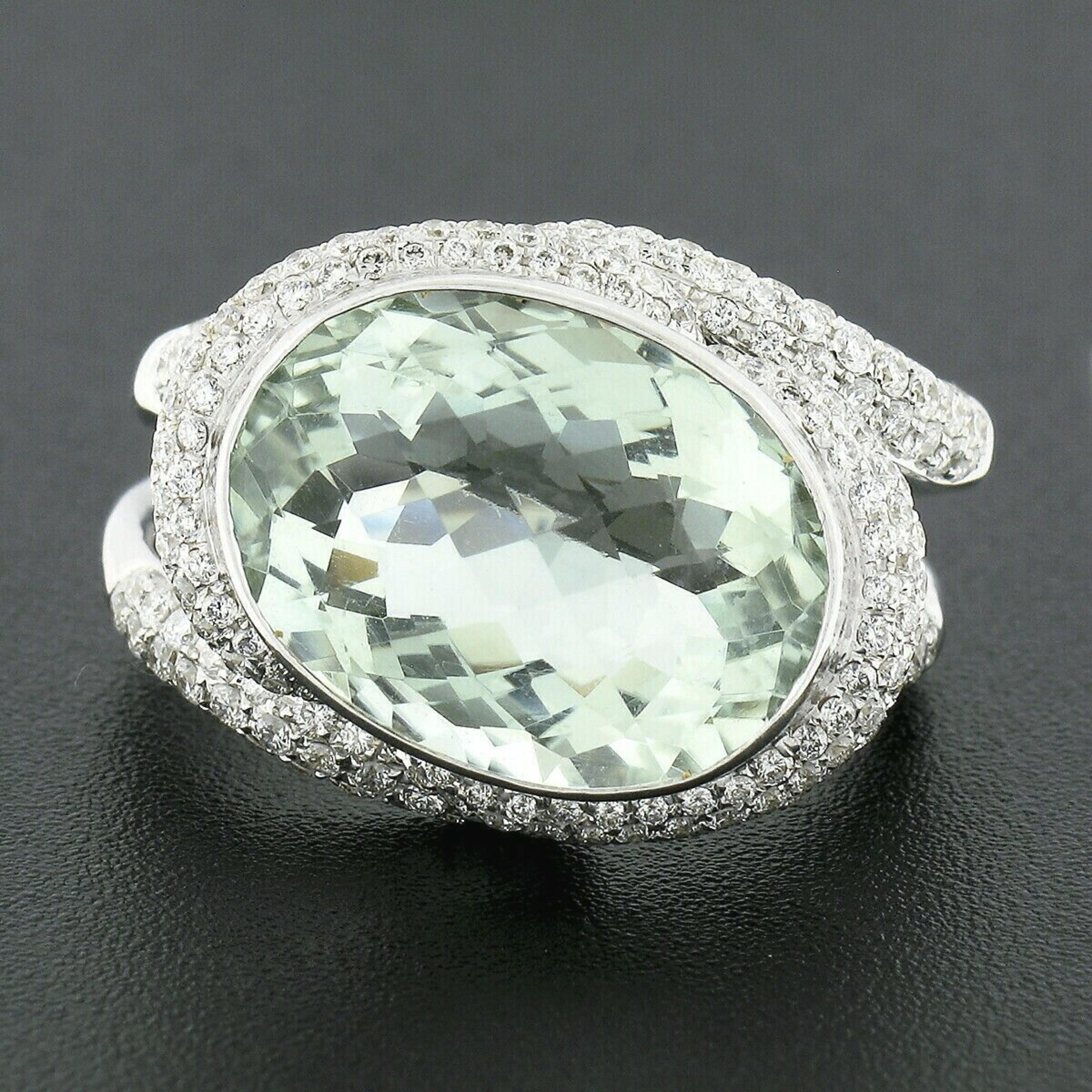 This breathtaking cocktail ring is crafted in solid 18k white gold and features a gorgeous oval cut prasiolite quartz neatly bezel set at the center. This large stone has a beautiful light mint green color that is very pleasant to observe and