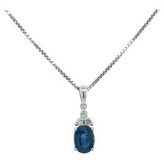 Collana con pendente a tre pietre in oro bianco 18K con zaffiro blu ovale e diamante