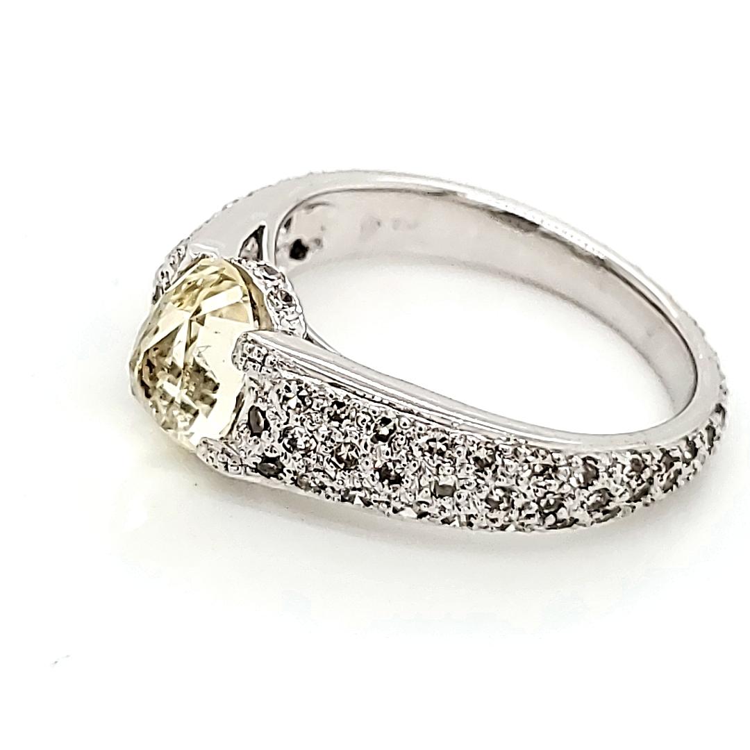 At its heart lies a resplendent oval-shaped yellow sapphire, weighing 1.45 carats, radiating warmth and vitality. 

It is intricately crafted in a mesmerizing rose cut.

Encircling this luminous gemstone are delicate round diamonds, totaling 0.69