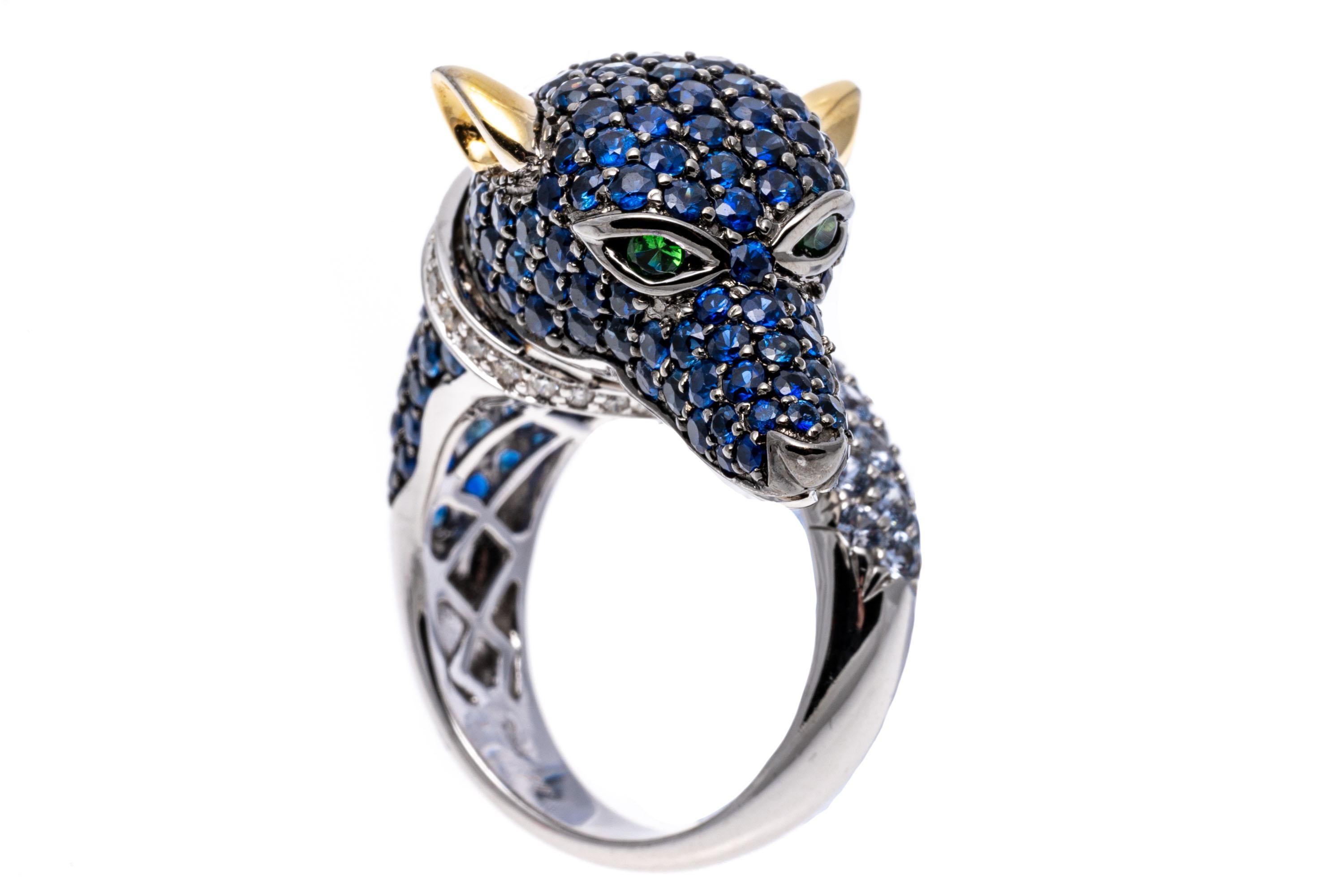 18k white gold ring. This gorgeous ring by Neda Behnam is a white gold center figural dog head that curls back on itself to the tail, pave set on the head with round faceted, medium blue color sapphires, approximately 4.97 TCW. and pave set on the