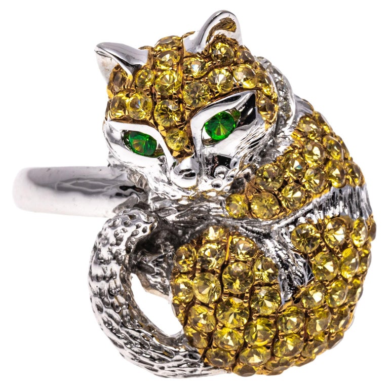 18k white gold ring. This adorable ring is a white gold, figural cat motif, pave set with round faceted, light yellow color topaz, approximately 0.95 TCW and decorated with a collar of round faceted white diamonds, approximately 0.02 TCW. The ring