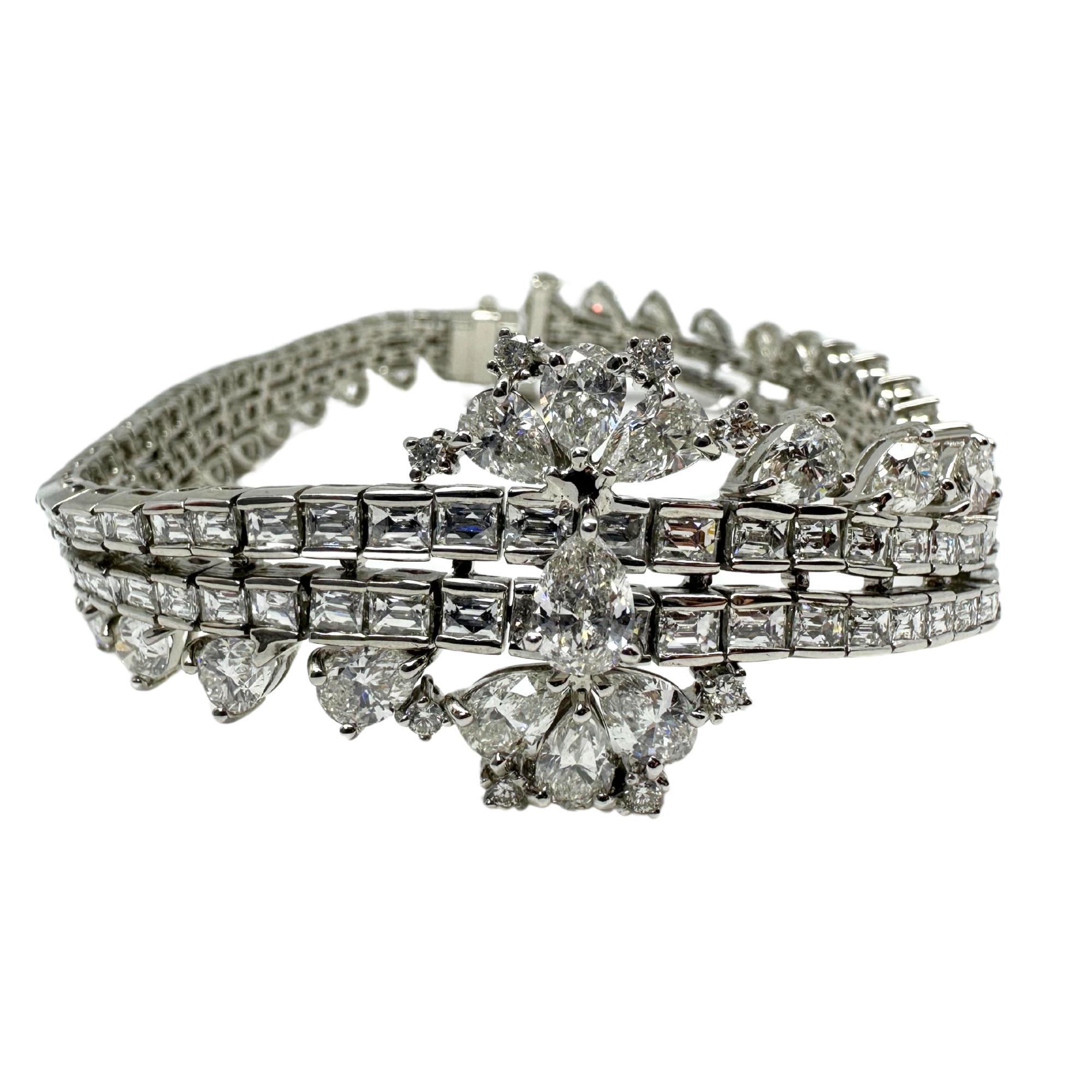 Abbagliante e intricato, questo bracciale in oro bianco 18 carati mette in mostra ben 16,18 carati di diamanti con taglio a pera e baguette in uno splendido design a strati. Gli imponenti gruppi di diamanti floreali e la struttura a tre file offrono