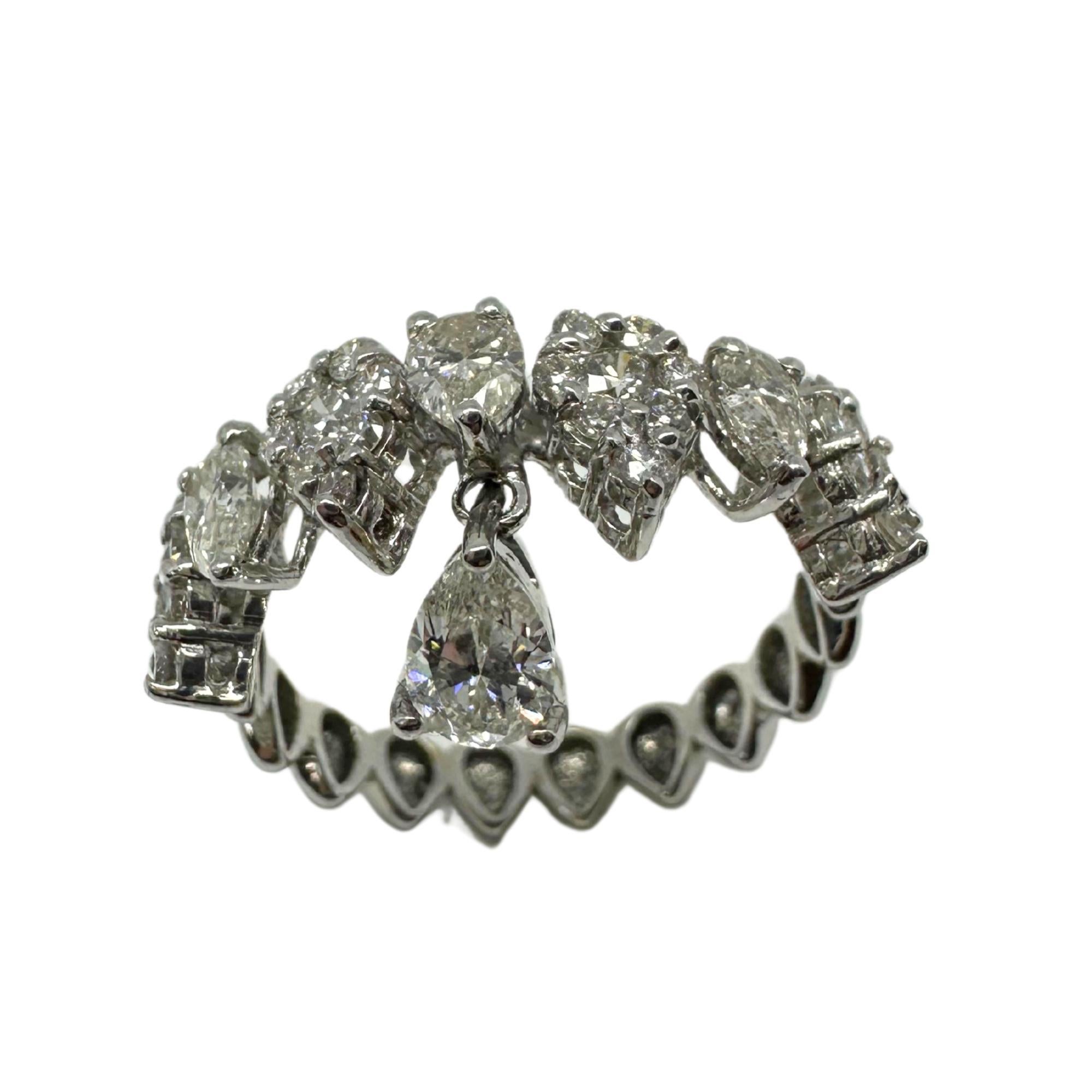 Questo anello con diamante in oro bianco 18 carati presenta un design unico e giocoso con un dettaglio penzolante, che aggiunge movimento e scintille a ogni gesto. I diamanti a taglio pera sono elegantemente incastonati lungo la fascia, con uno